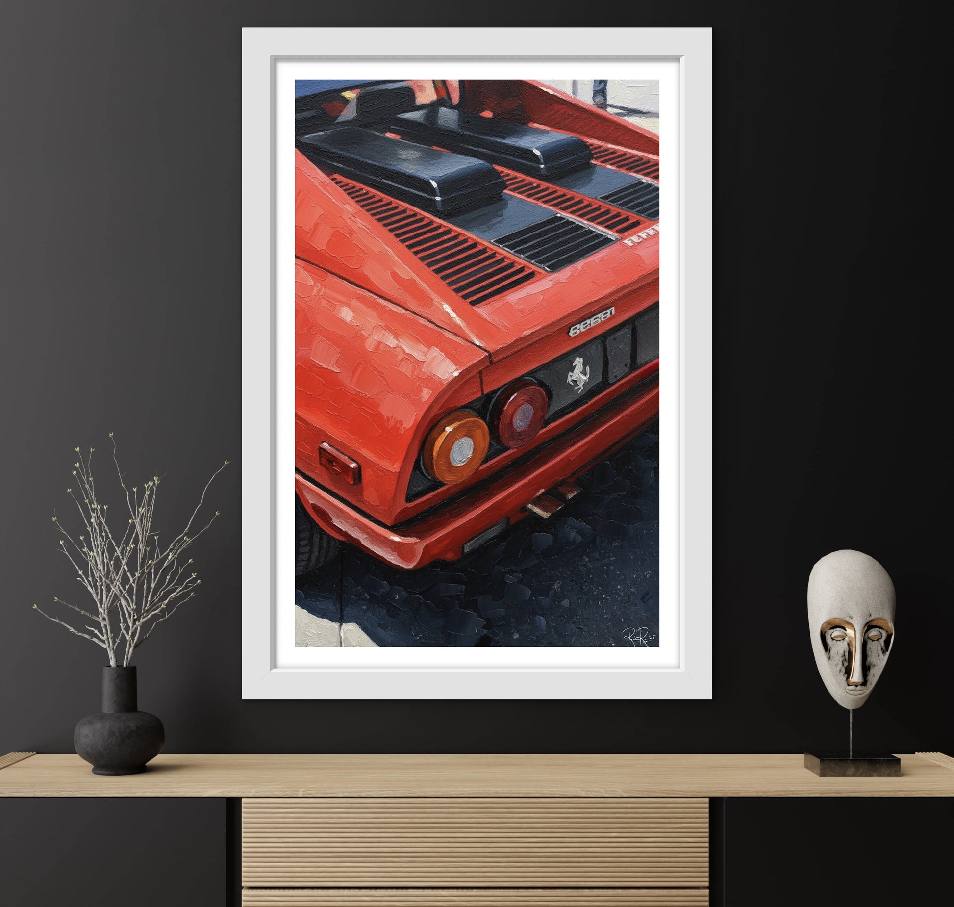 Framed poster of a red Ferrari on a dark wall with decorative items.
