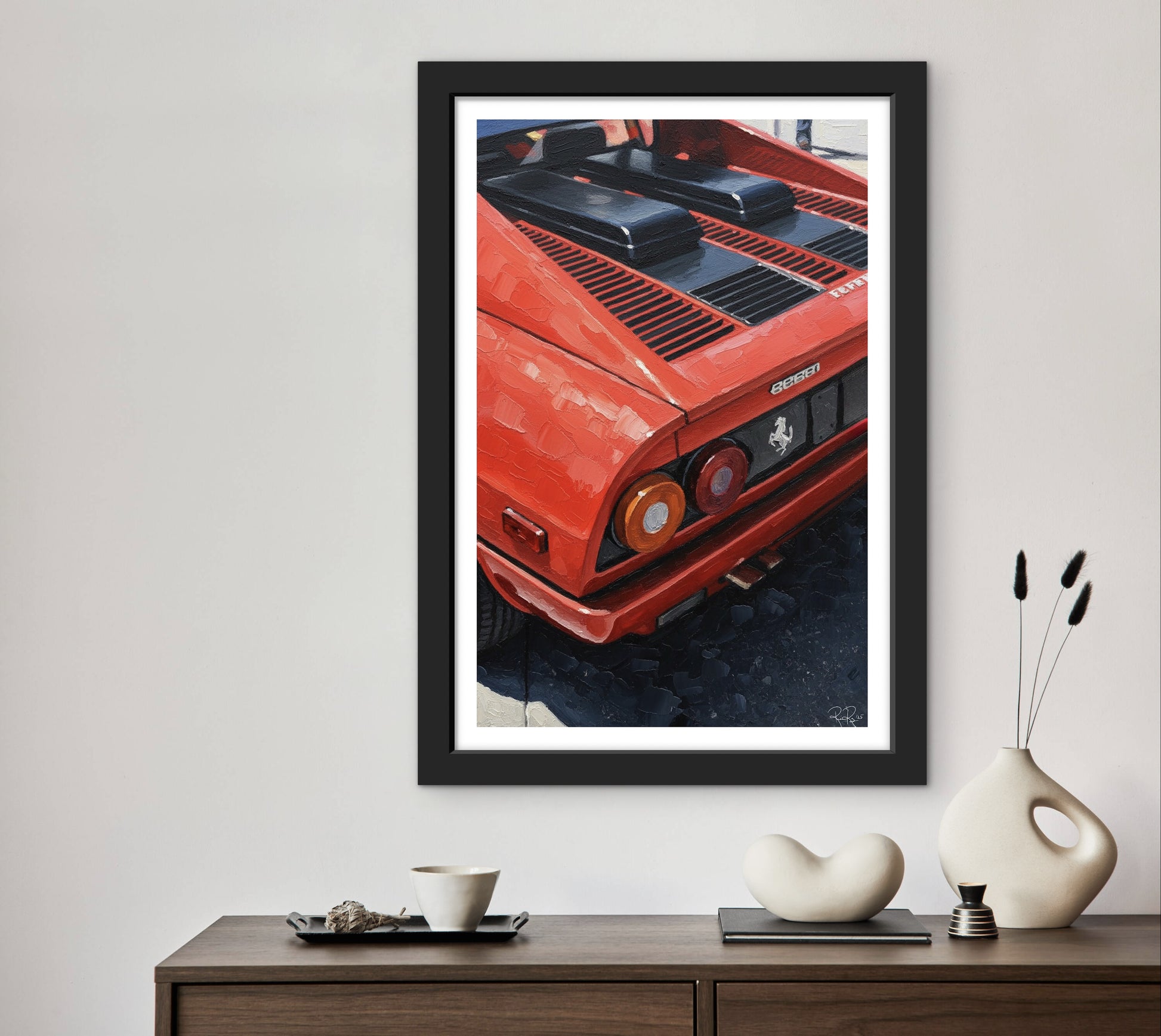 Framed artwork of a red car on a wall above a wooden console table with decorative items.