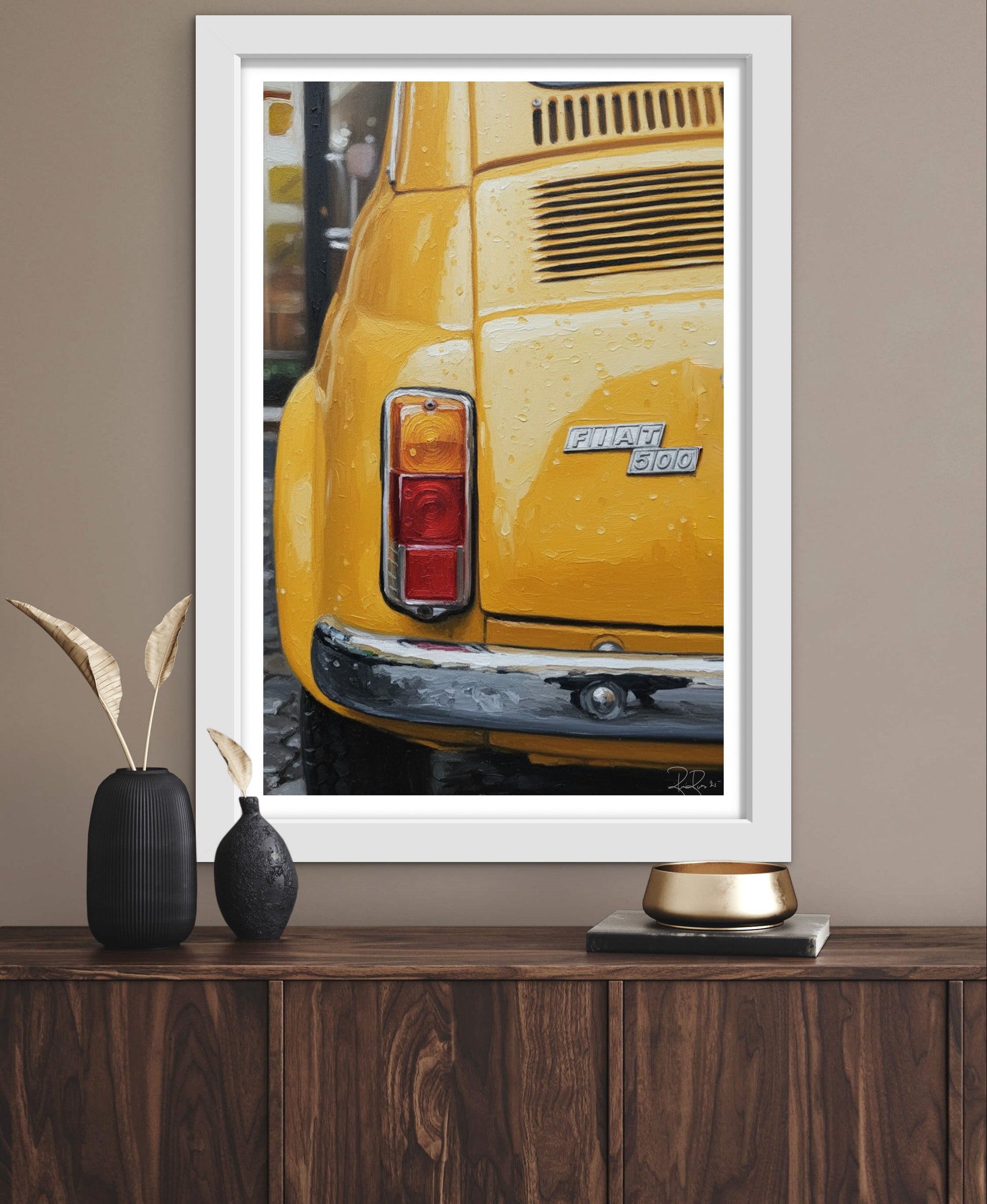 Framed artwork of a yellow car on a wooden surface with decorative items.