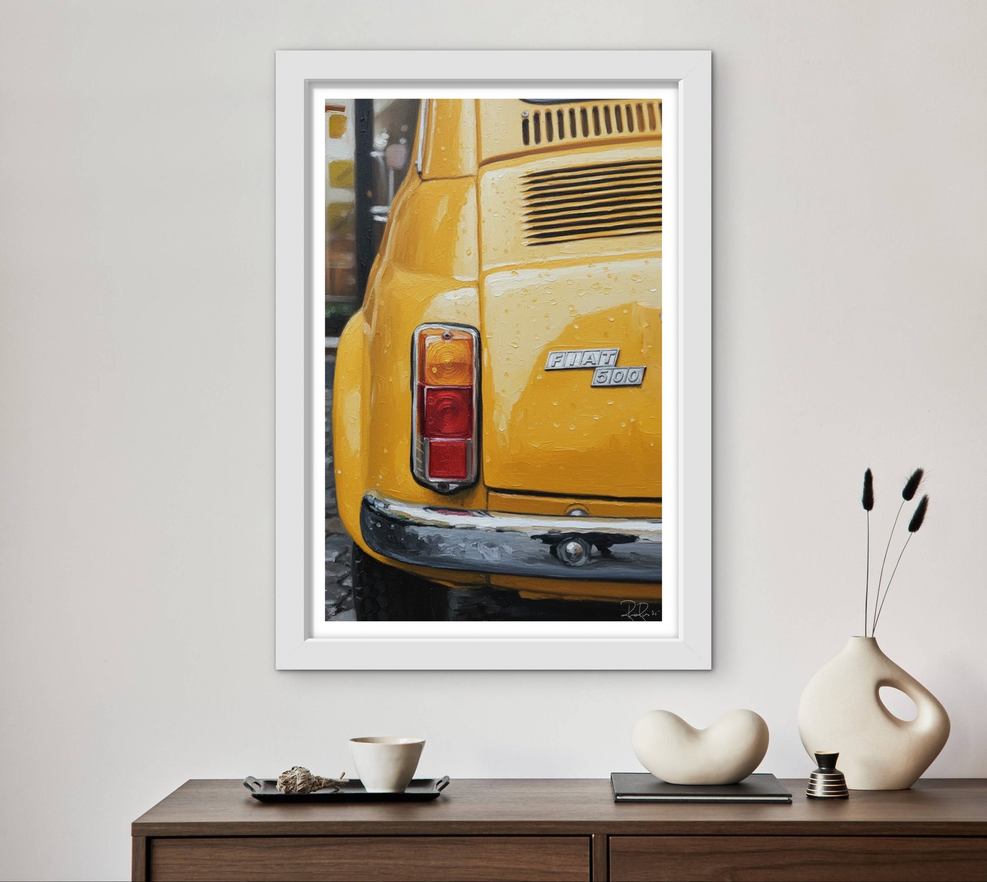 Framed photograph of a yellow car on a wall above a wooden console table with decorative items.