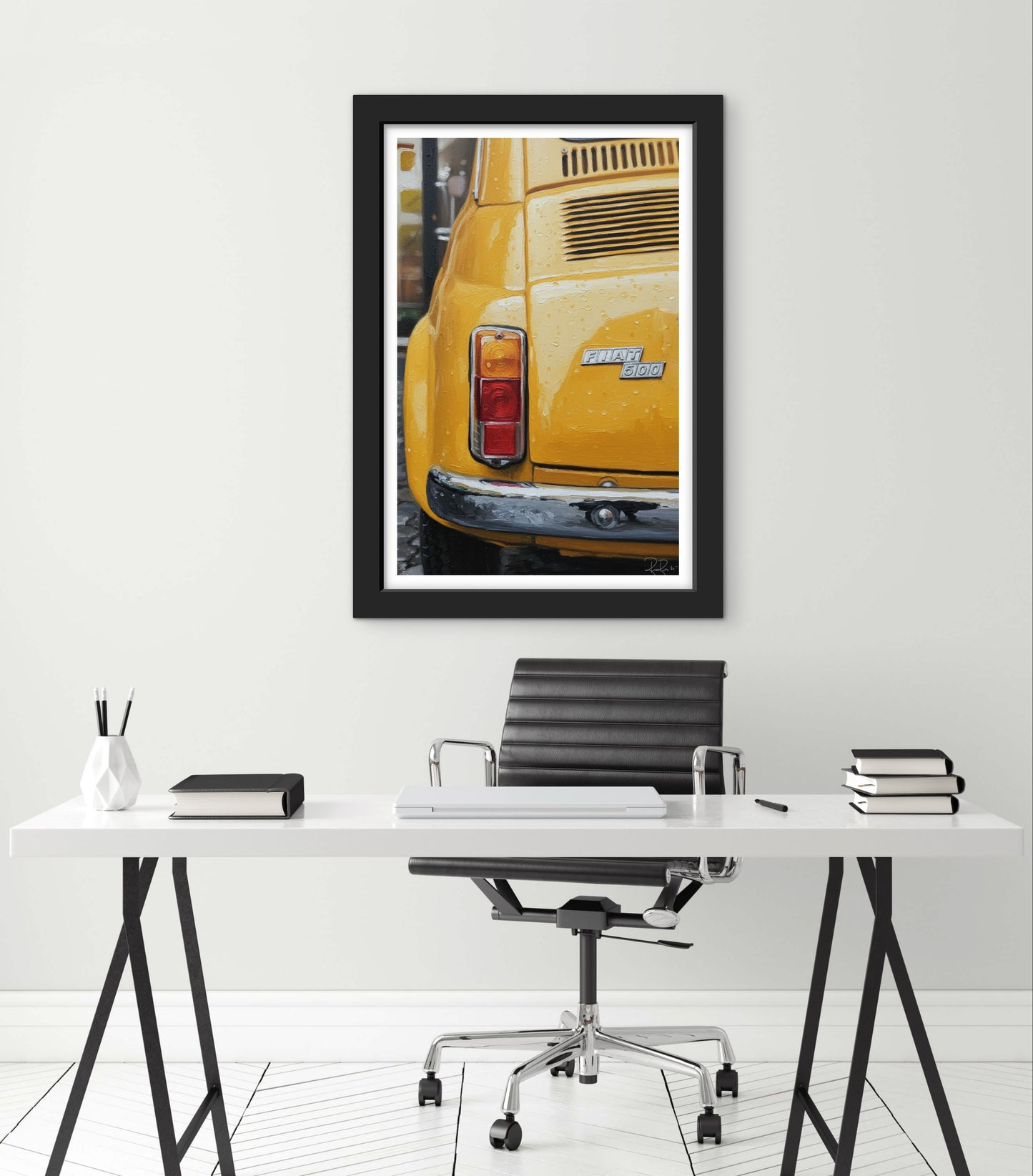 Framed picture of a yellow car on a white wall above a desk.
