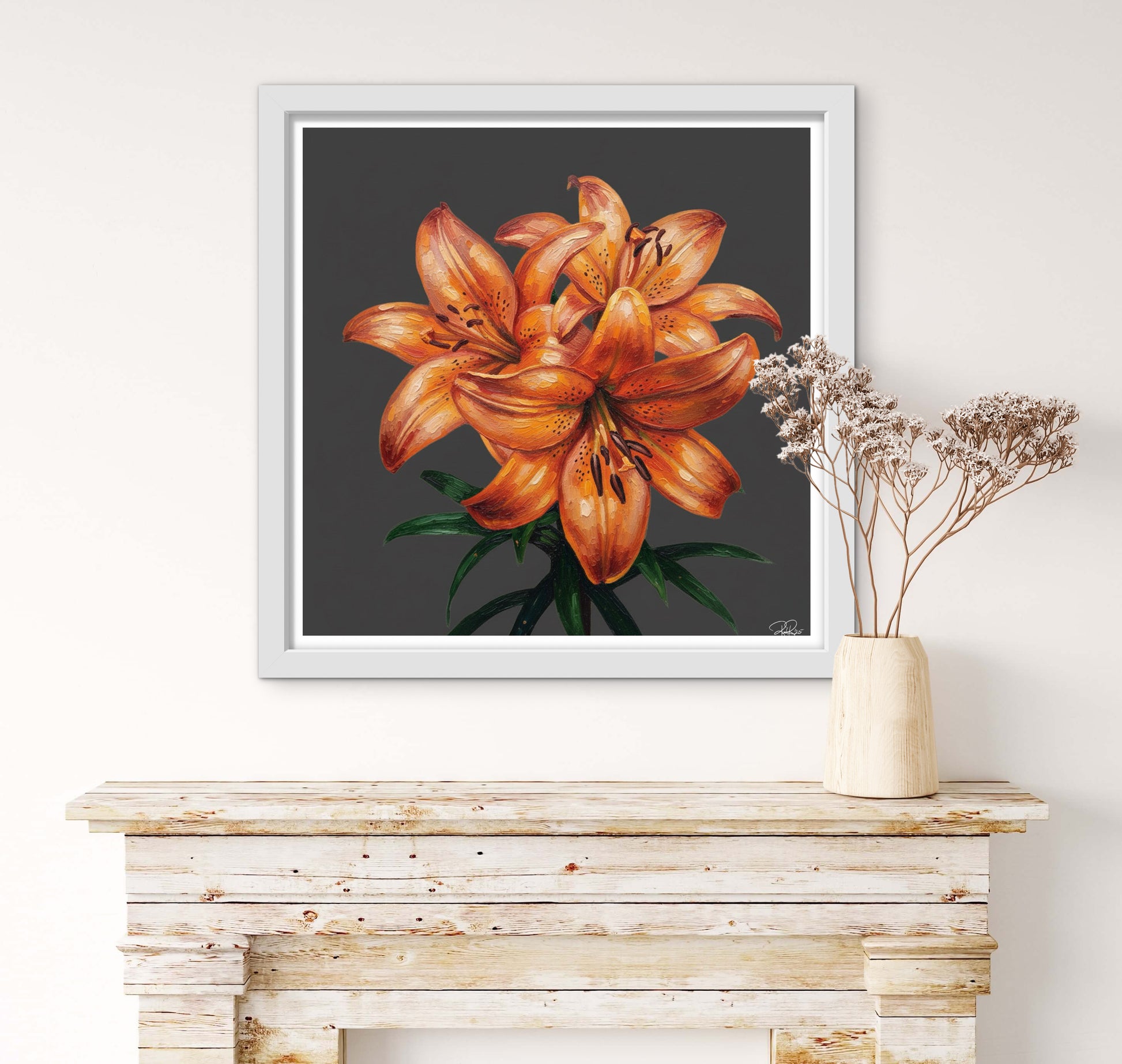 Framed artwork of orange lilies on a wall above a wooden console table.