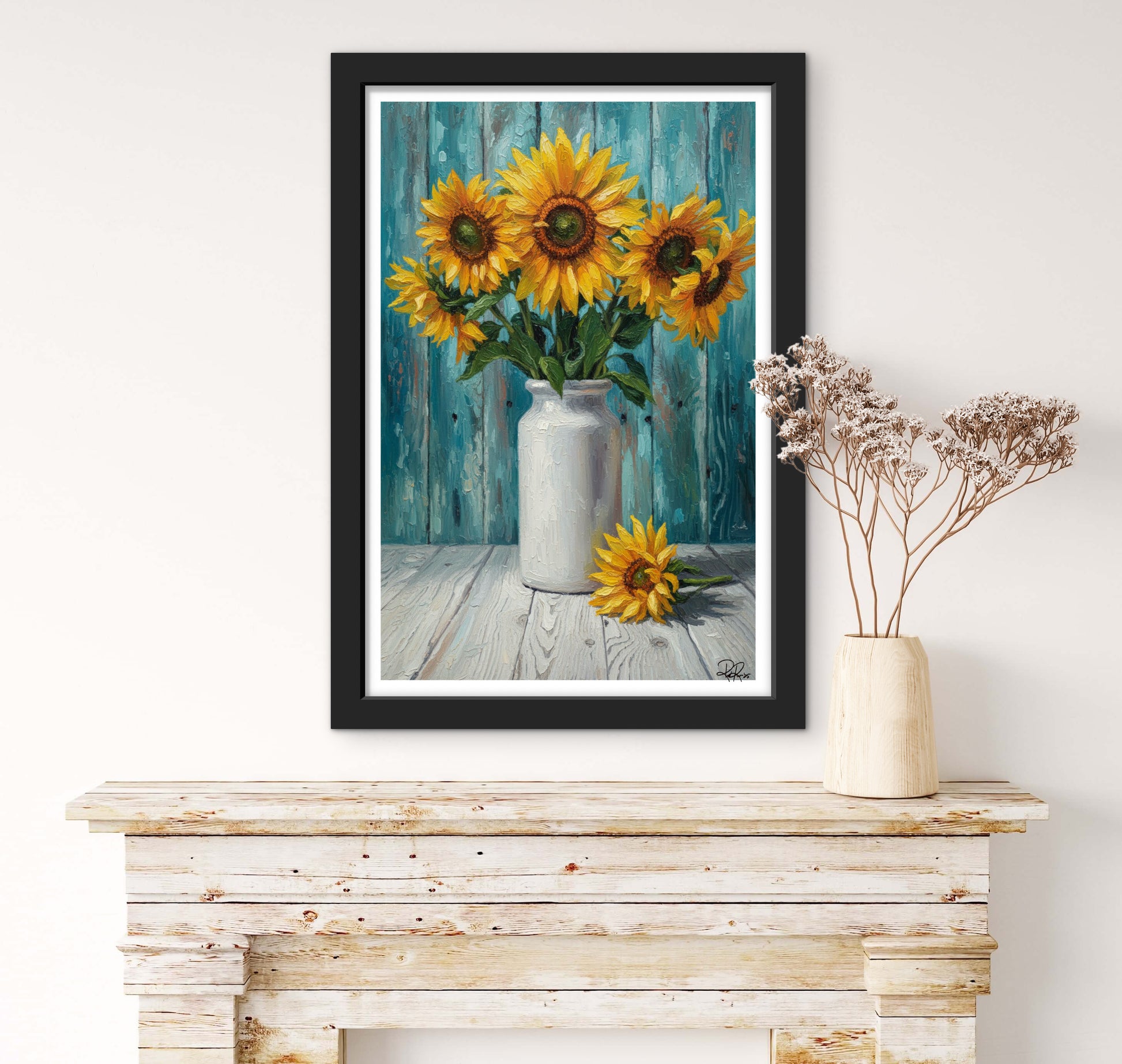 Framed artwork of sunflowers in a vase on a wooden surface with a white wall background.