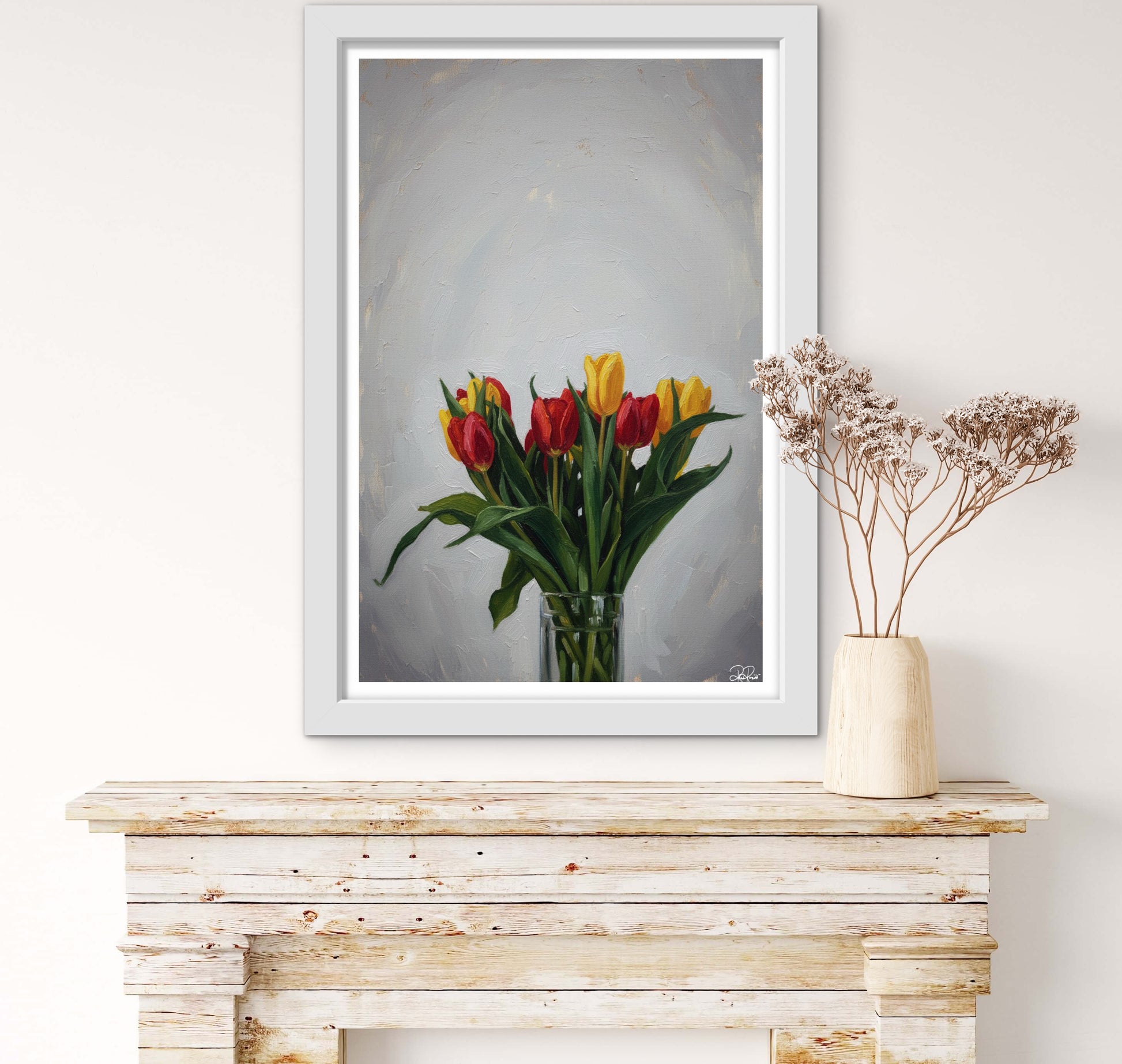 Framed artwork of tulips on a wooden console table with a vase of flowers.