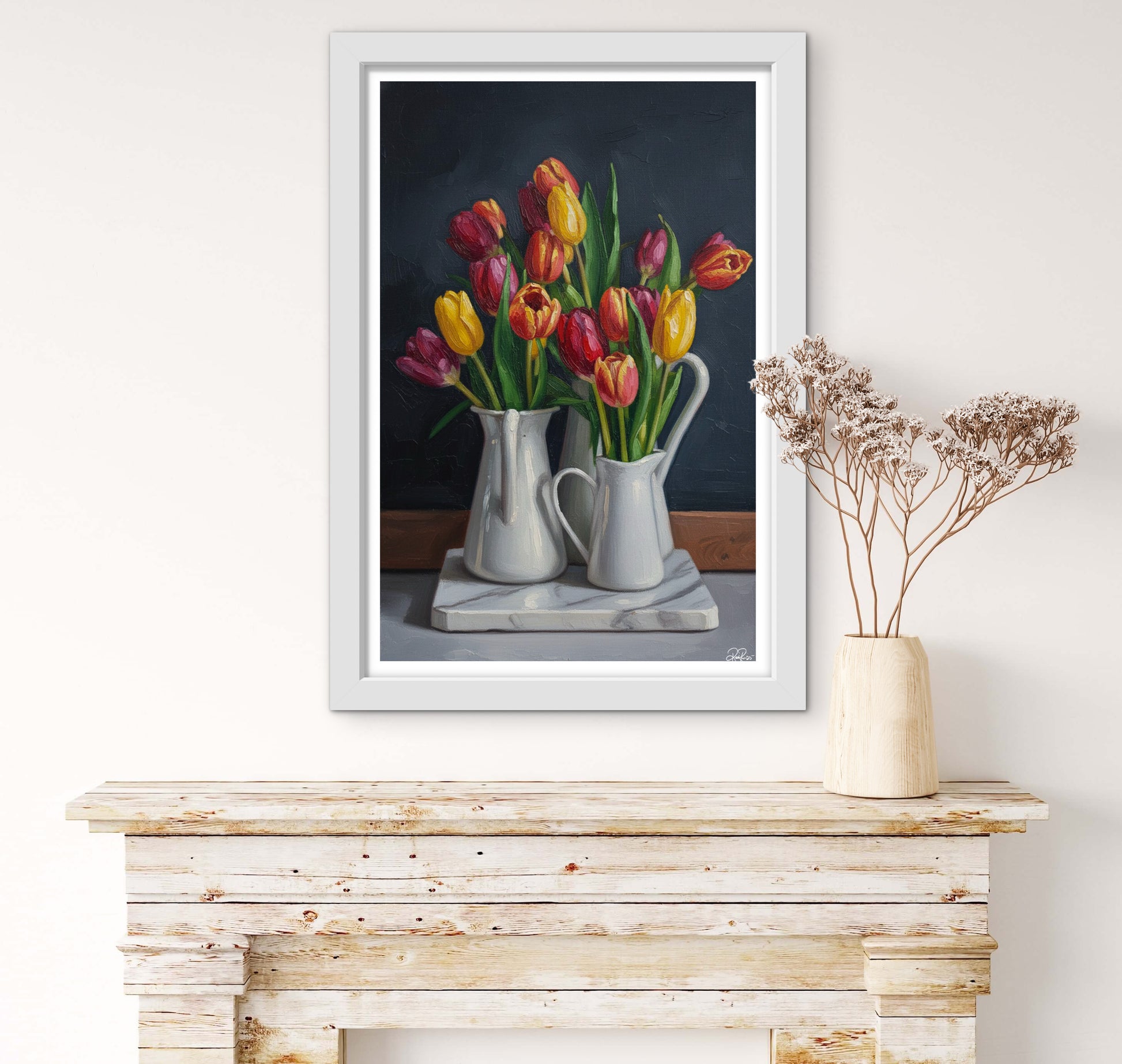 Framed painting of tulips on a wooden surface with a vase of dried flowers.