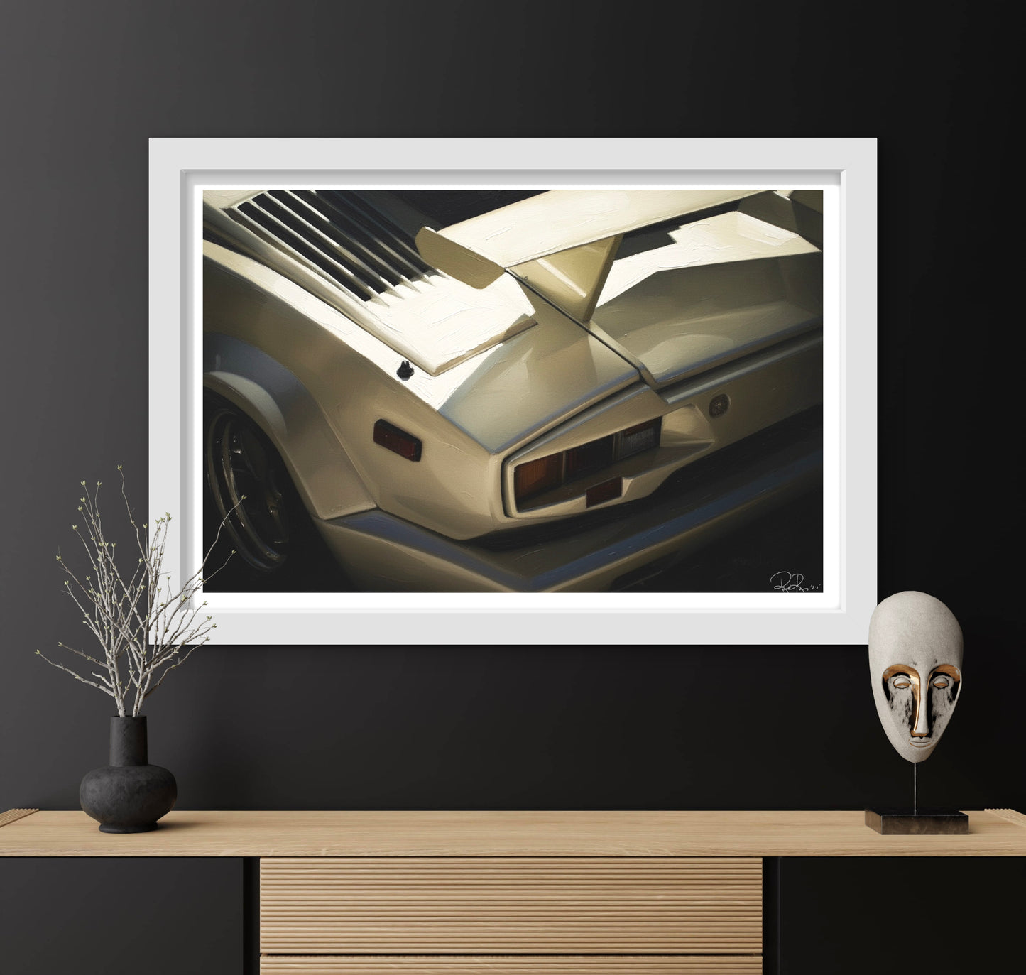 Framed artwork of a vintage car on a dark wall with decorative items below.