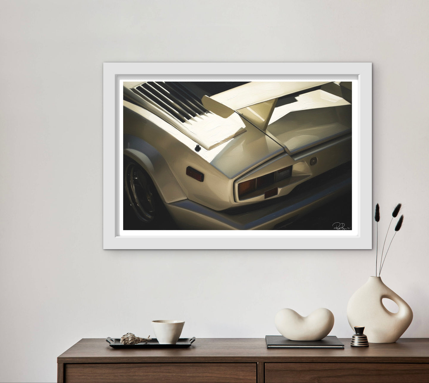 Framed artwork of a car on a wall above a wooden console table with decorative items.