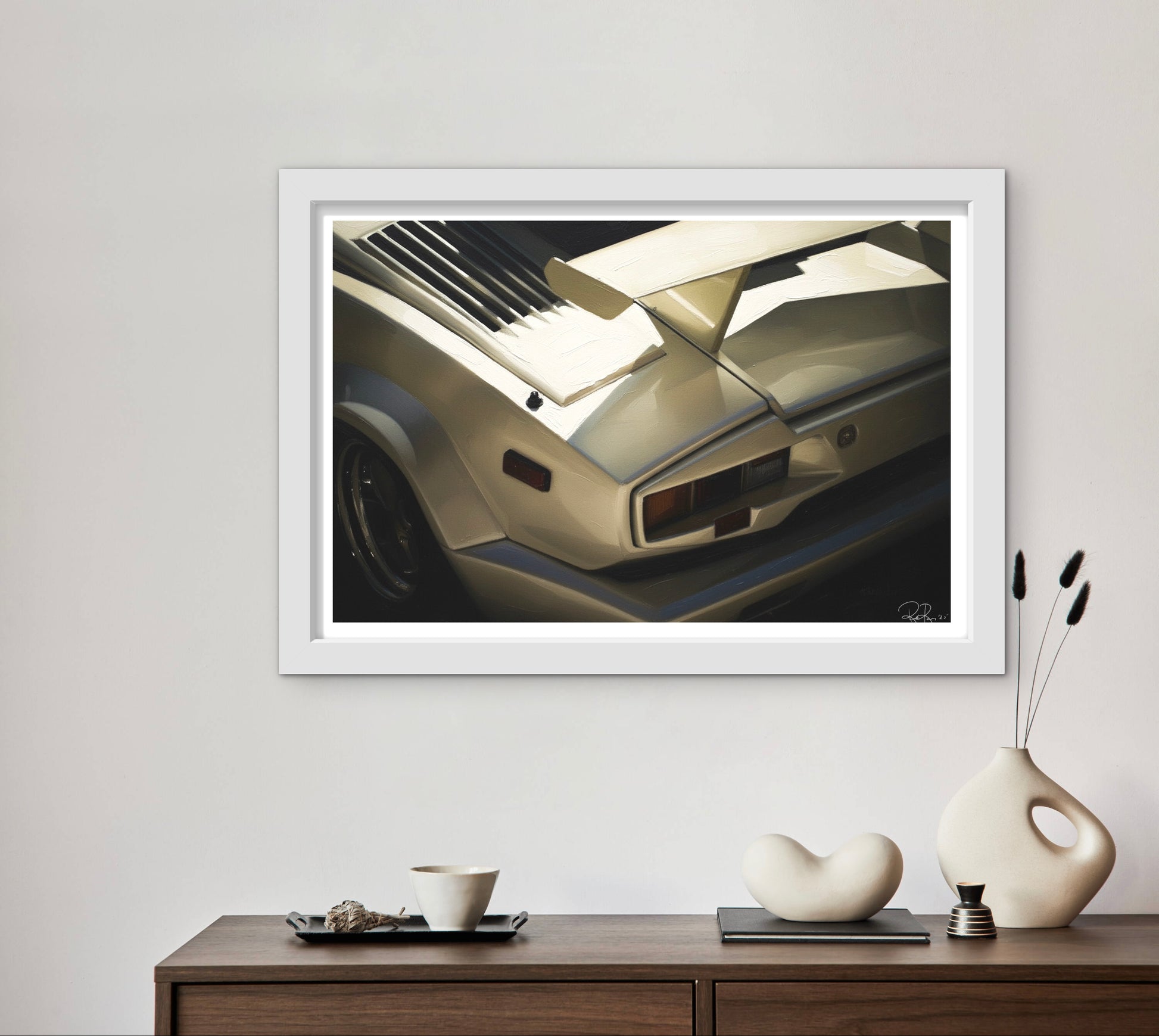 Framed artwork of a car on a wall above a wooden console table with decorative items.