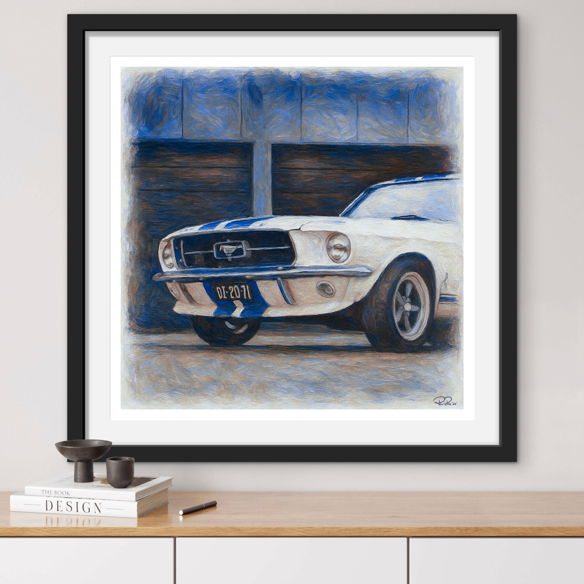 Framed painting of a classic car on a wall above a wooden shelf.