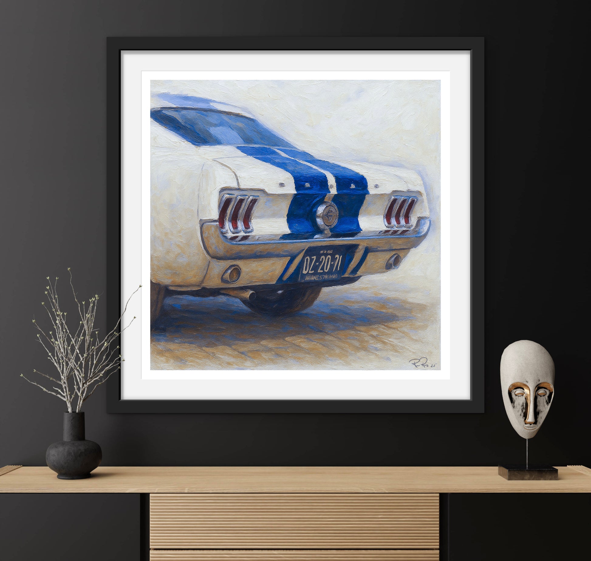 Framed artwork of a classic car on a dark wall with decorative items.