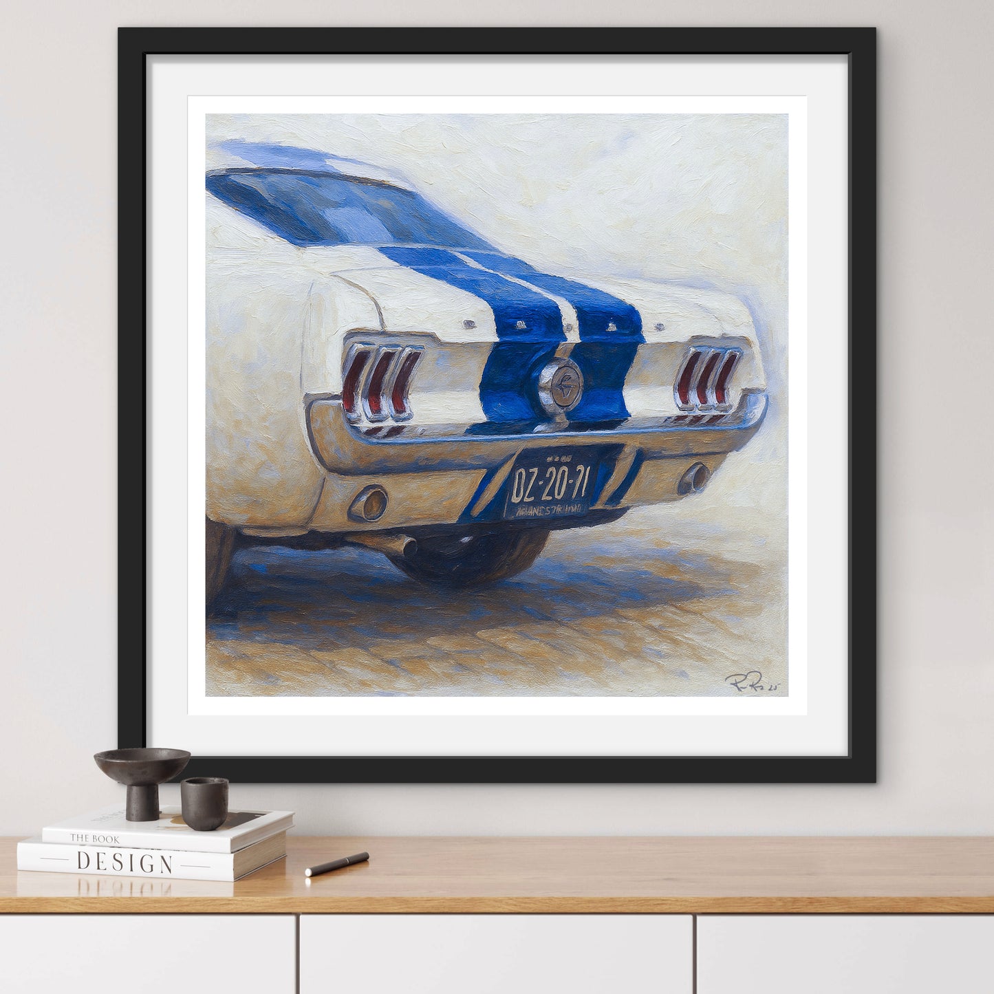 Framed artwork of a classic car with blue stripes on a white wall.