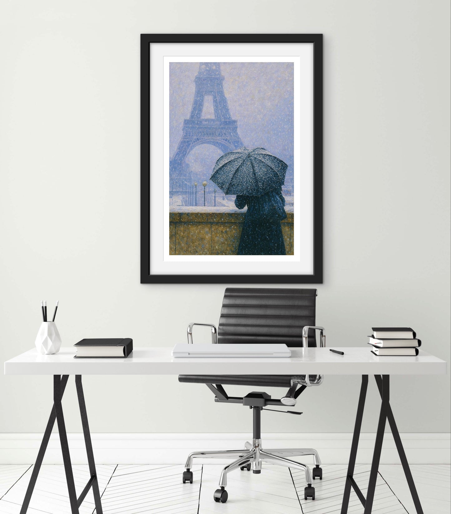 Framed artwork of a person with an umbrella under the Eiffel Tower in a home office setting.