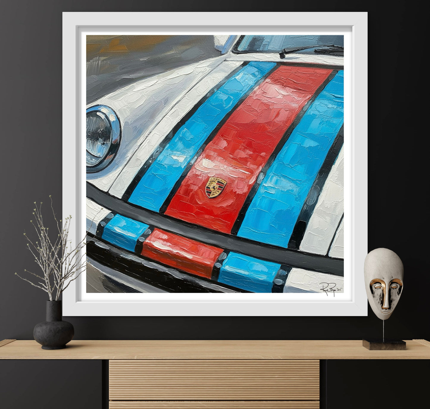 Framed artwork of a car with red and blue stripes on a shelf.