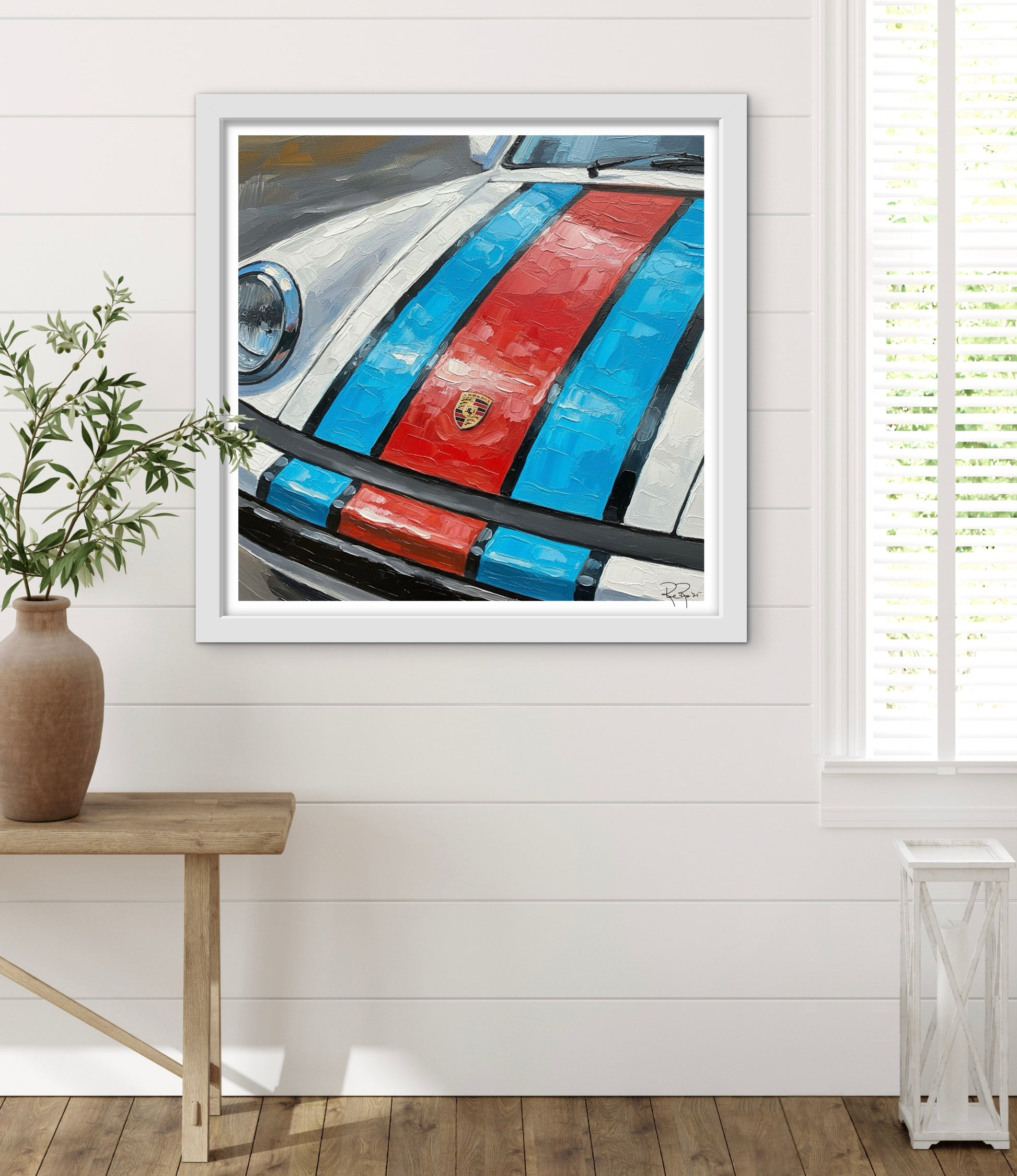 Framed artwork of a car with red and blue stripes on a white wall.