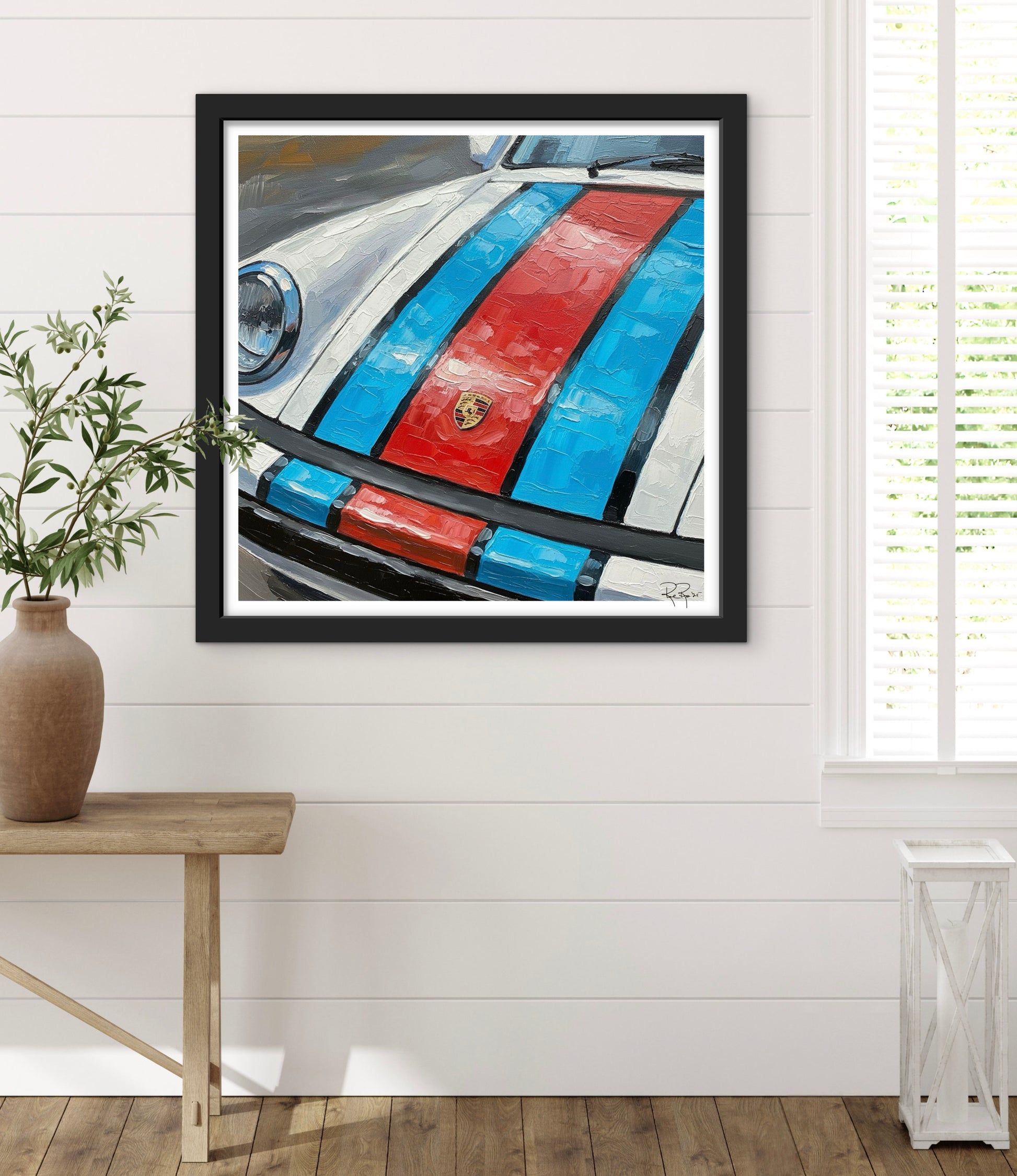 Framed artwork of a car with red and blue stripes on a white wall.