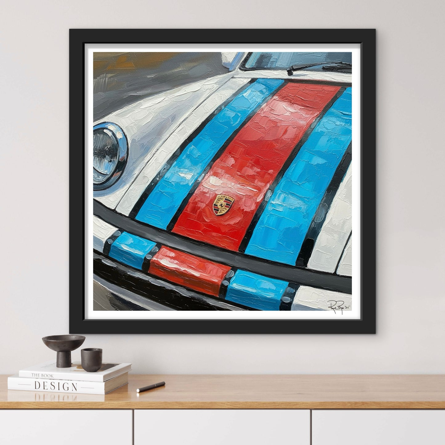 Framed artwork of a car with red and blue stripes on a white wall.