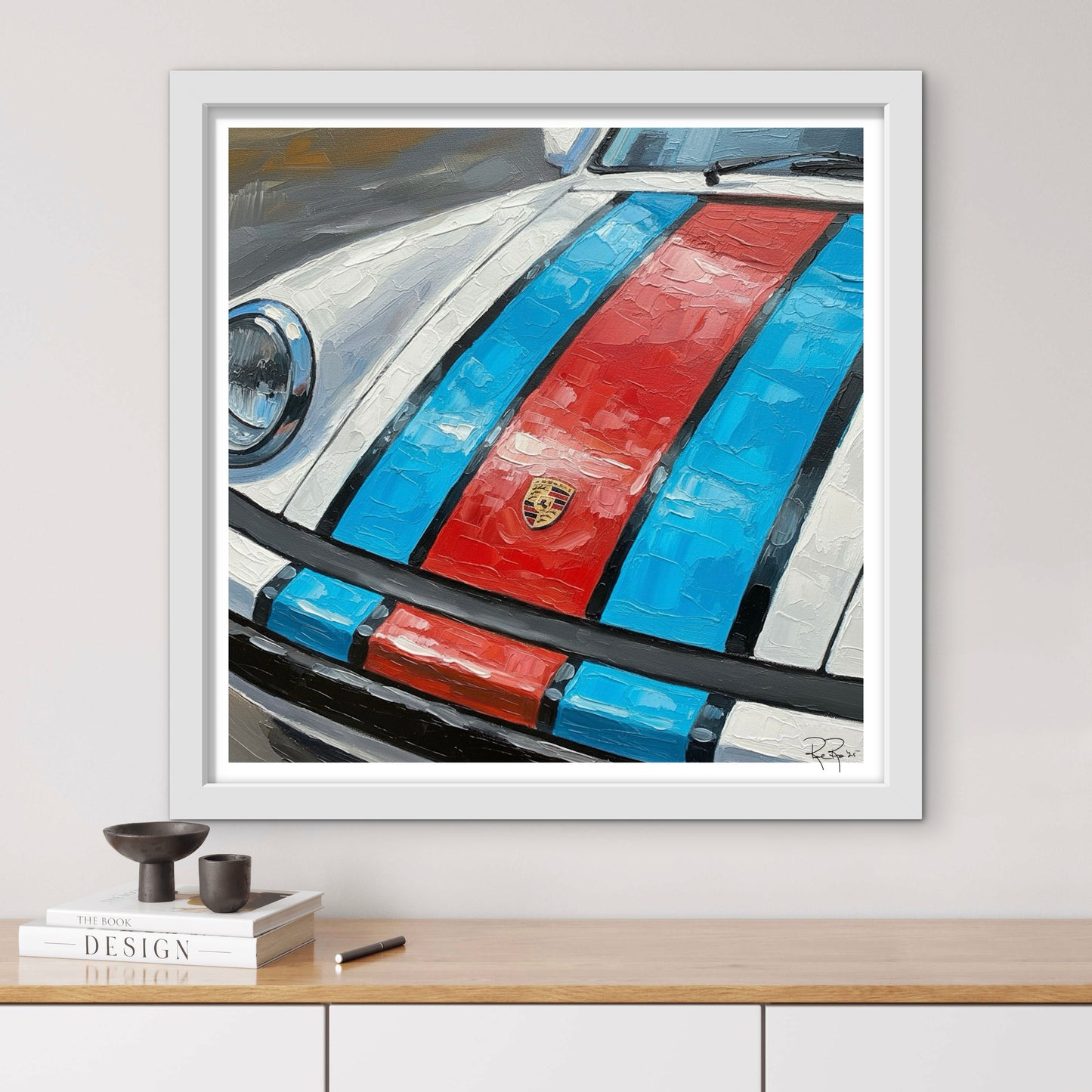 Framed artwork of a car with red and blue stripes on a white wall.