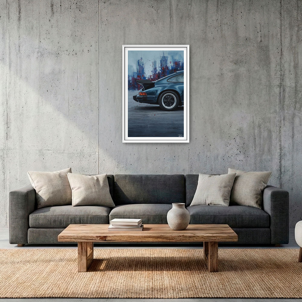 Gray sofa with a wooden coffee table in a room with a framed picture of a car on the wall.