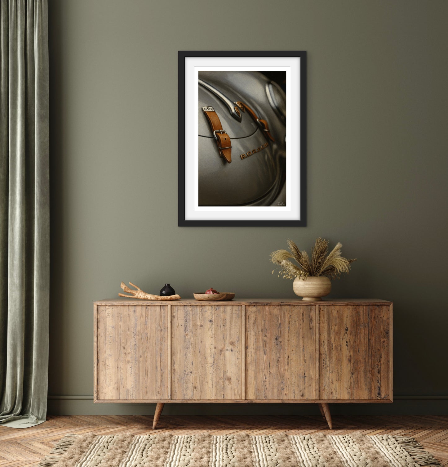 Framed picture on a wall above a wooden sideboard with decorative items.