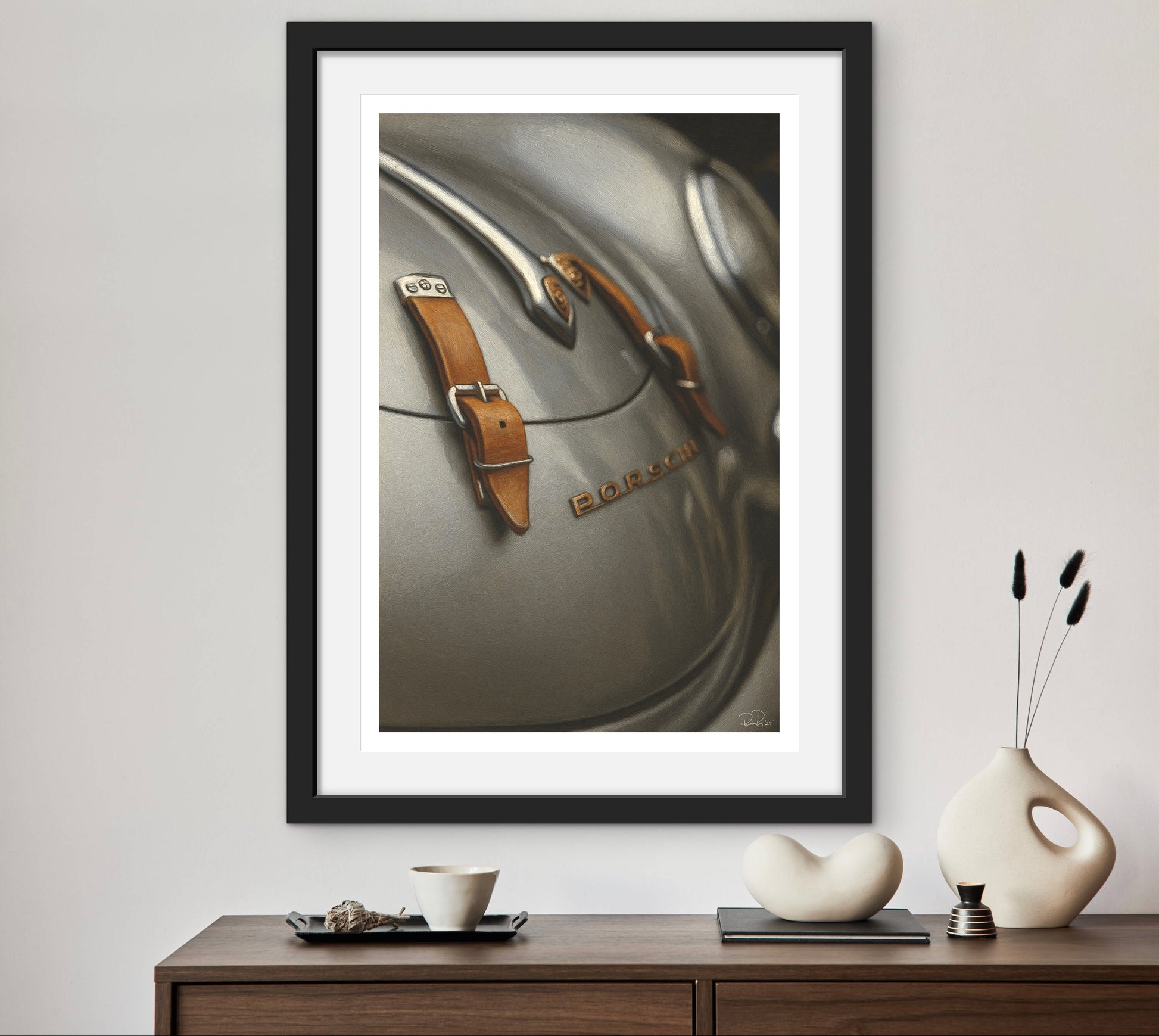 Framed artwork of a watch on a wall above a wooden console table with decorative items.