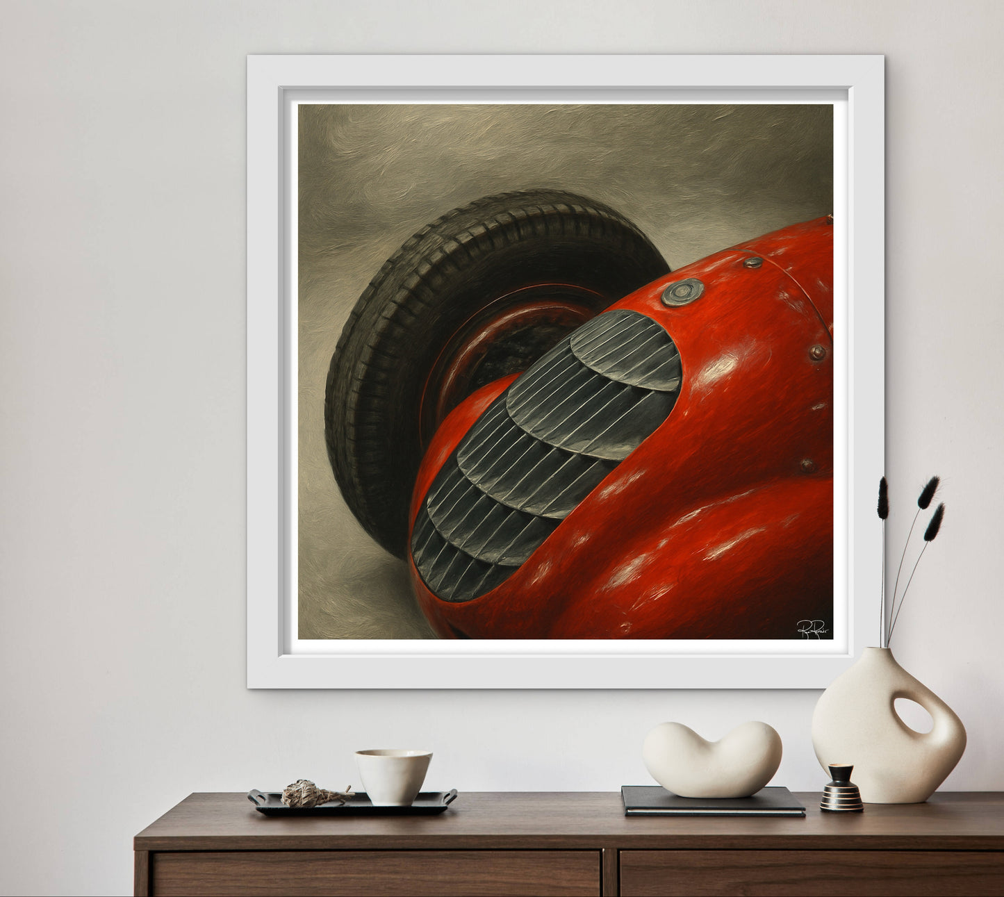 Framed artwork of a red vintage car on a wall above a wooden console table with decorative items.