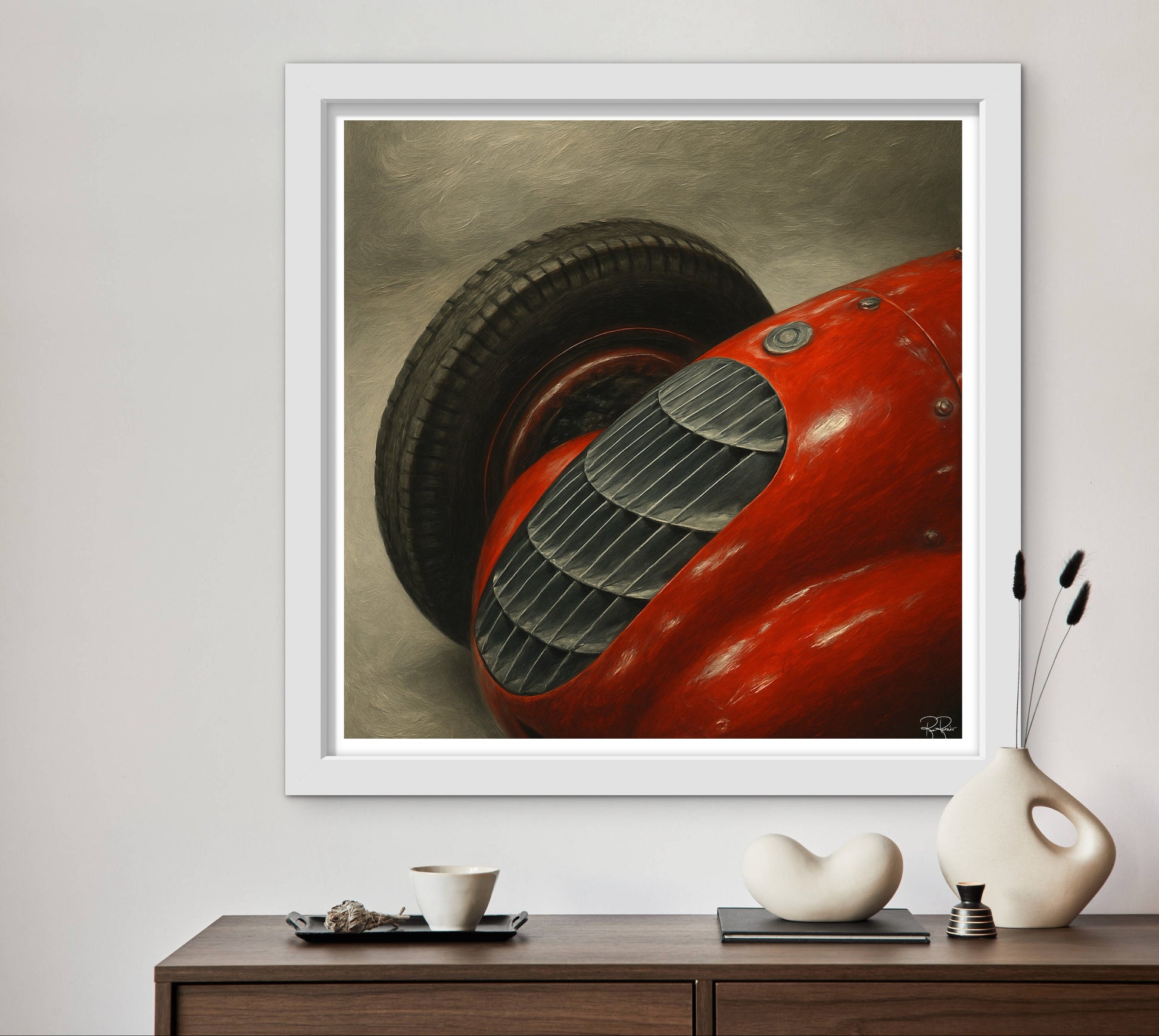 Framed artwork of a red vintage car on a wall above a wooden console table with decorative items.