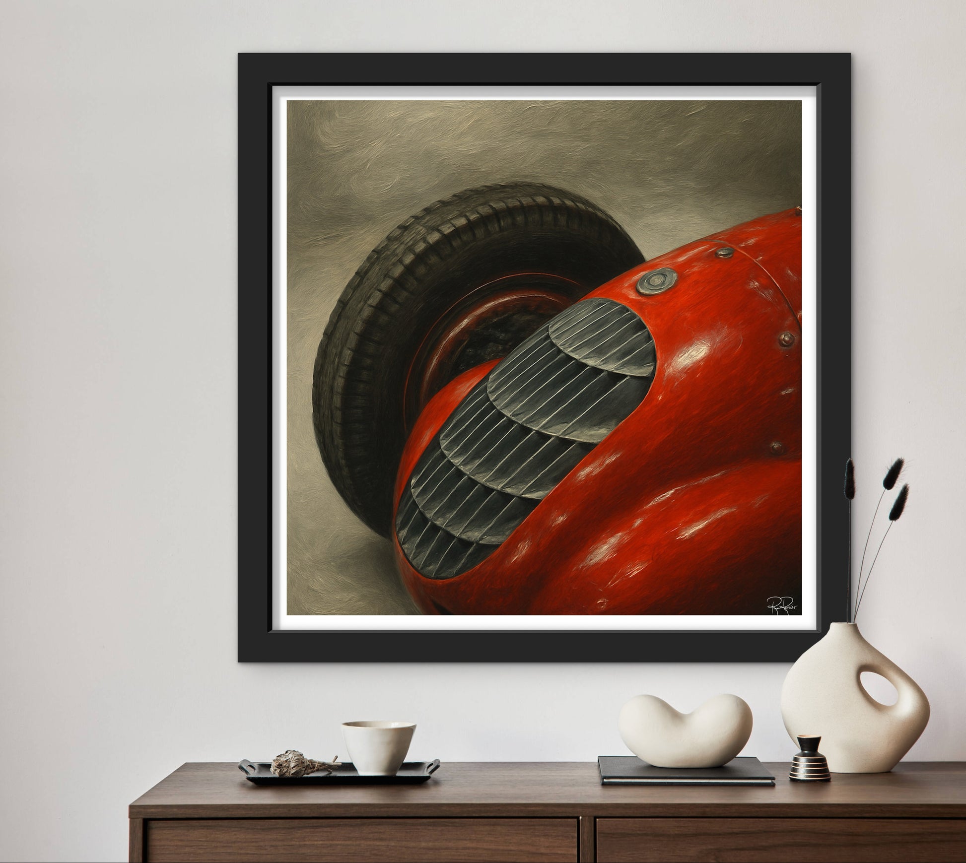 Framed artwork of a red vintage car on a wall above a wooden console table.