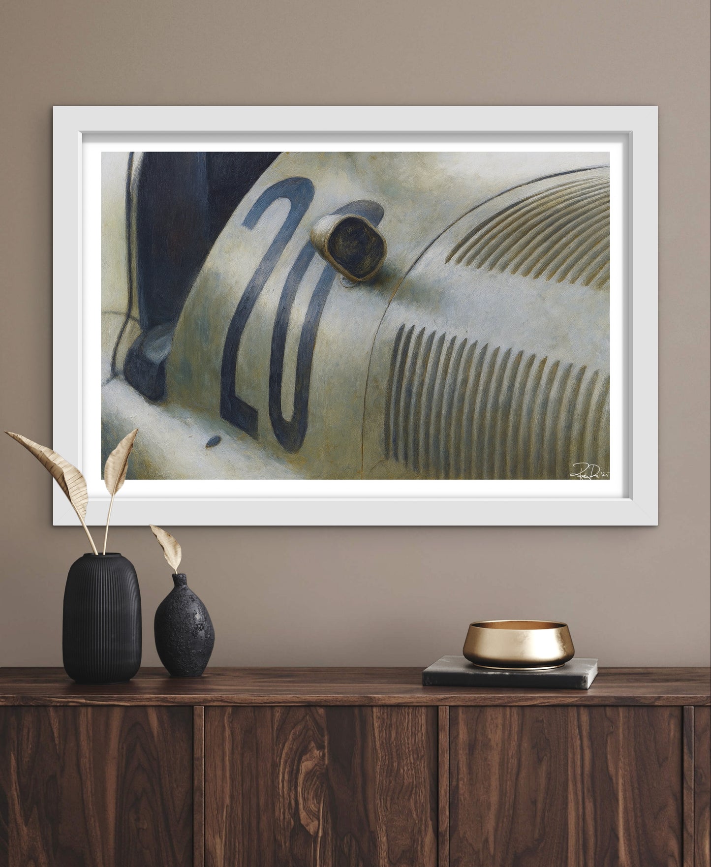 Framed artwork of a vintage car on a wall above a wooden console table.