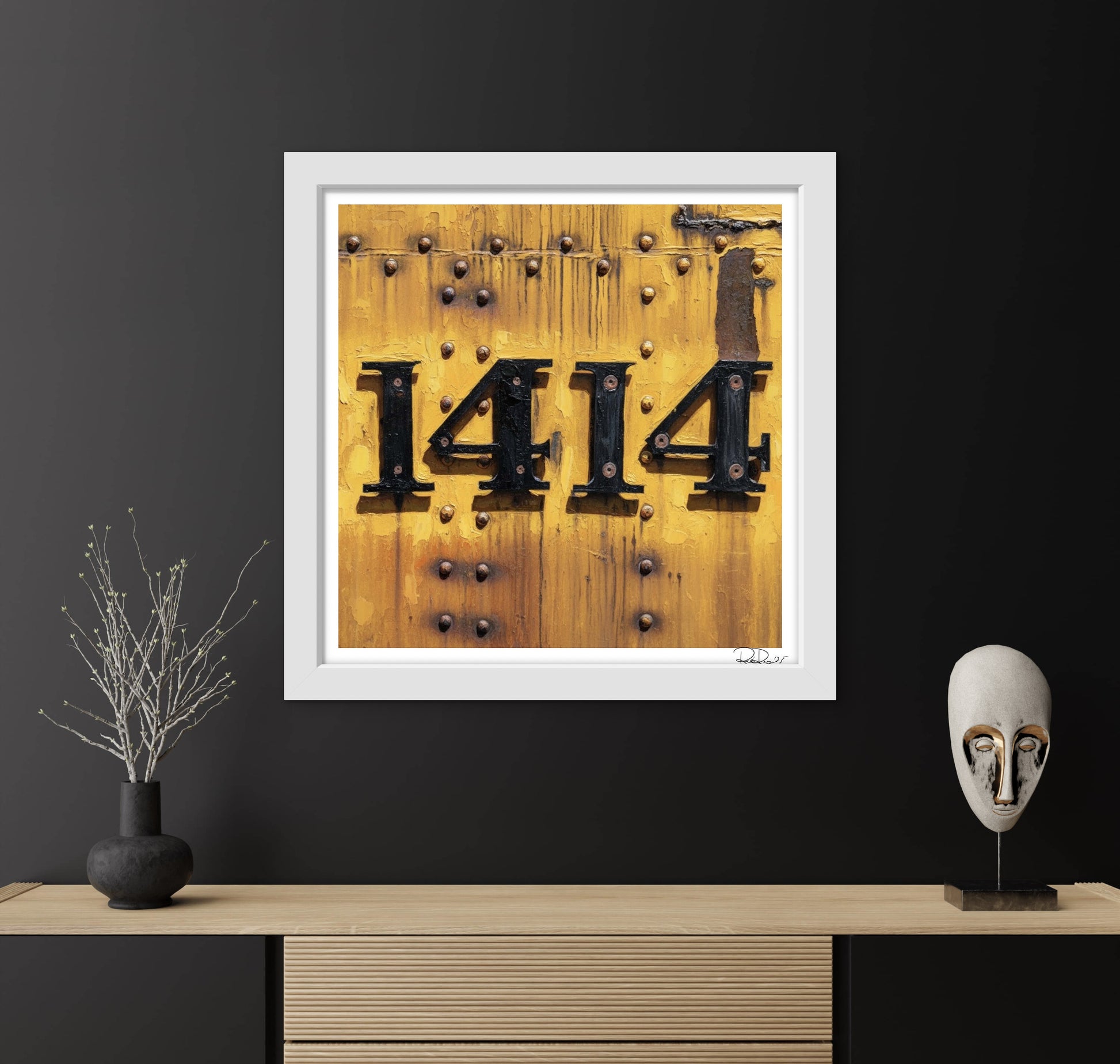 Framed artwork with '1414' on a wooden background, displayed on a dark wall with decorative items.