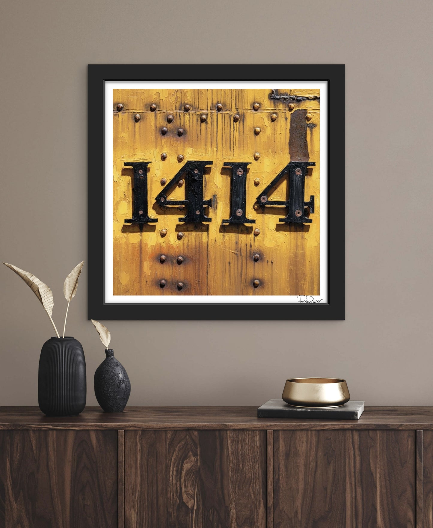 Framed artwork with the number '1414' on a wooden background, displayed on a wall above a wooden console table.