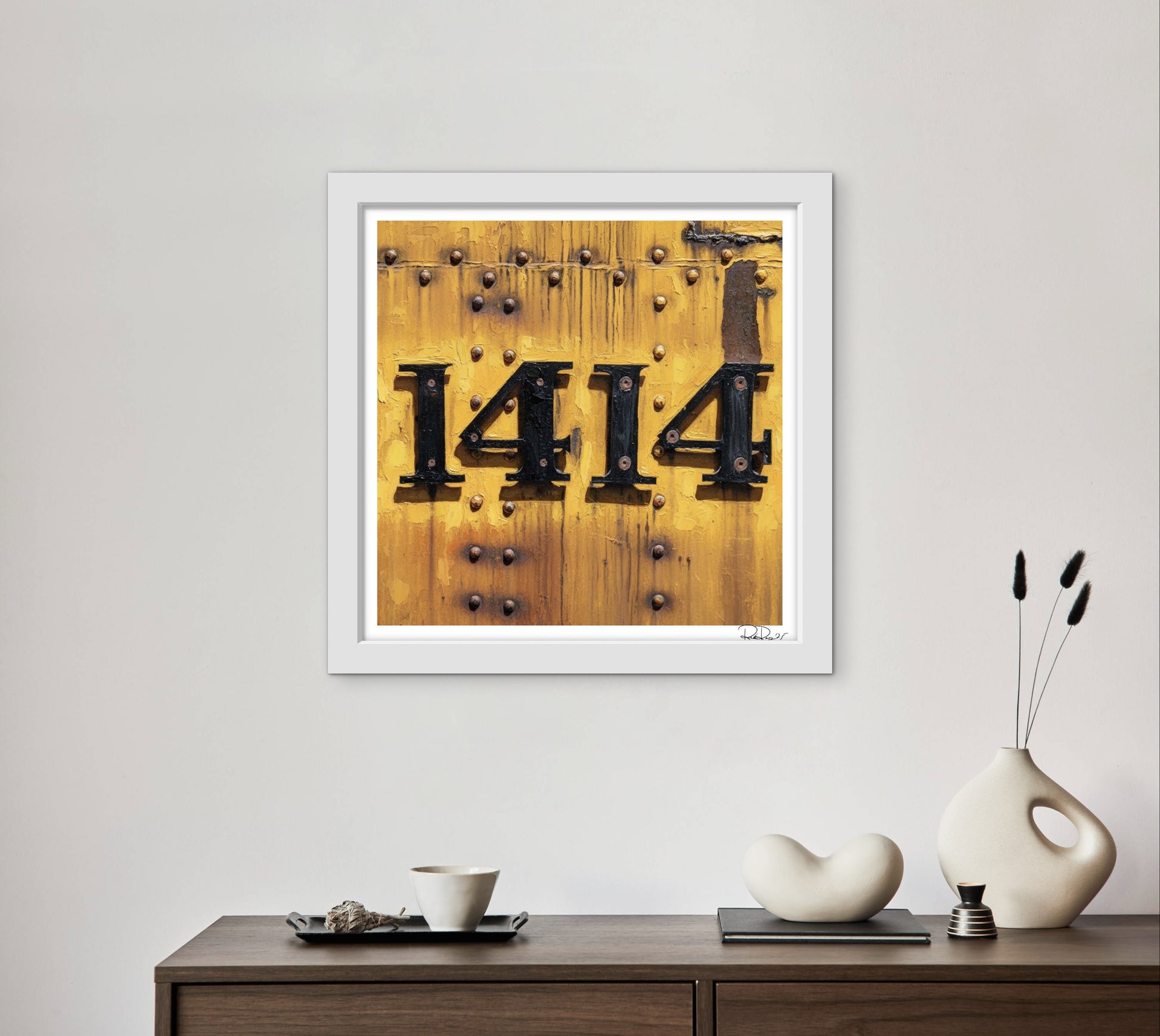 Framed artwork with the number '1414' on a wooden background, displayed on a wall above a wooden console table.