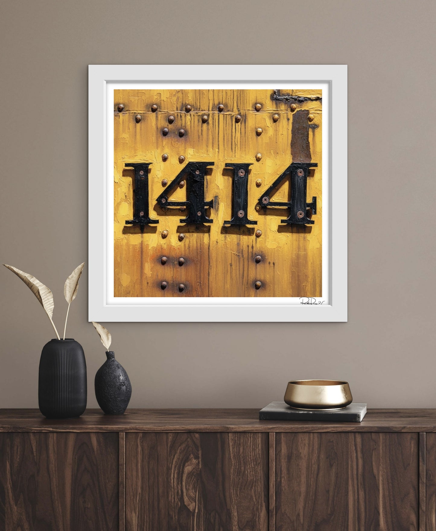 Framed artwork with the number '1414' on a wooden background, displayed on a wall above a wooden console table.