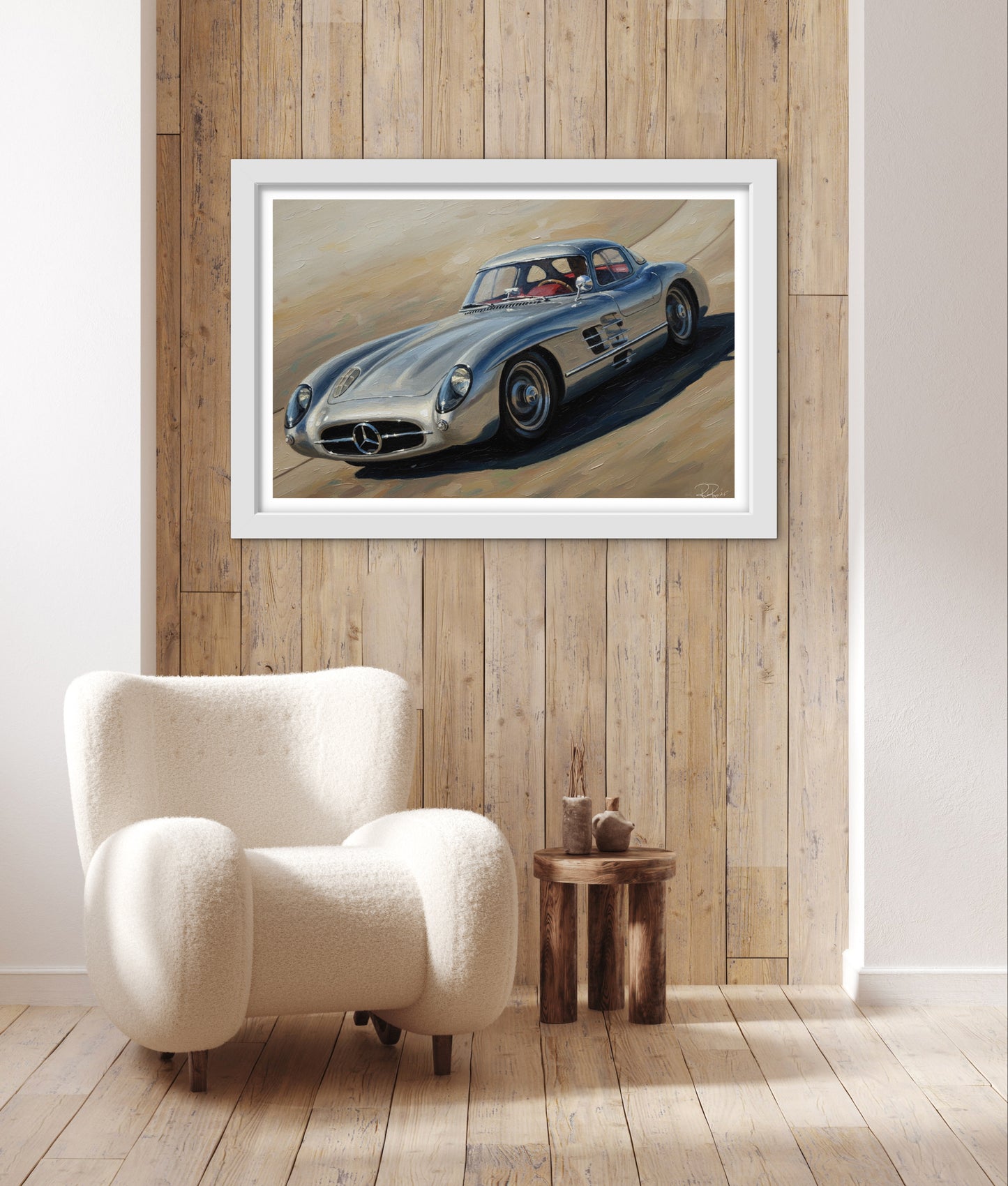 Framed artwork of a vintage car on a wooden wall above a white armchair.