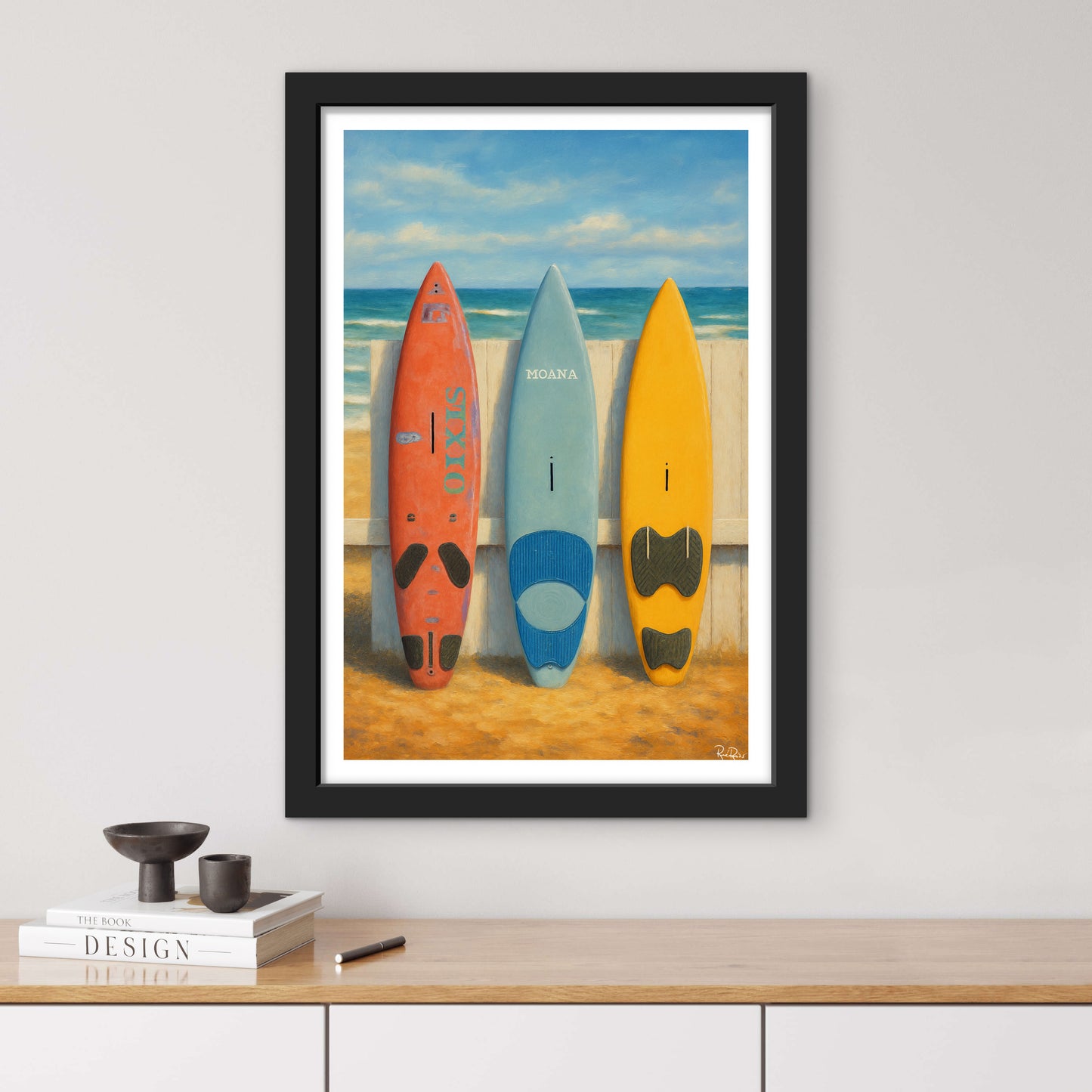 Framed artwork of three surfboards on a beach with a black frame.