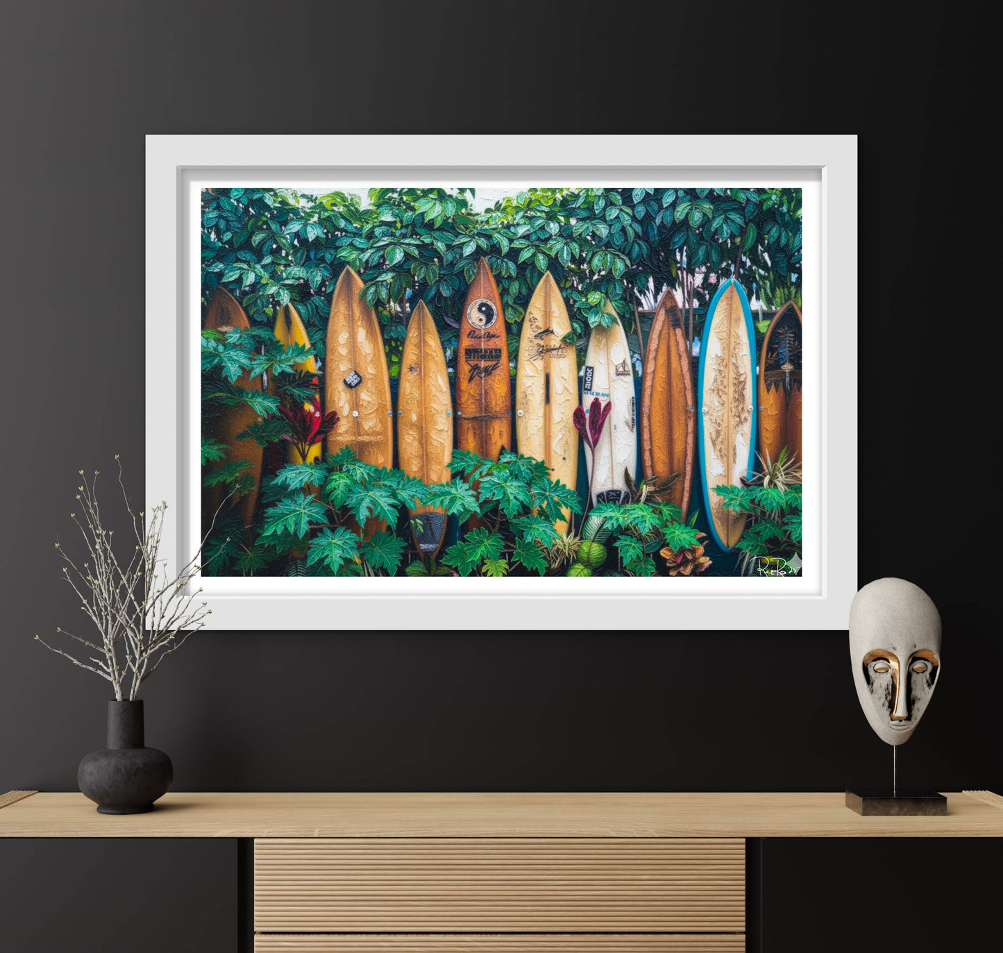 Framed artwork of surfboards in a forest displayed on a wall with decorative items below.