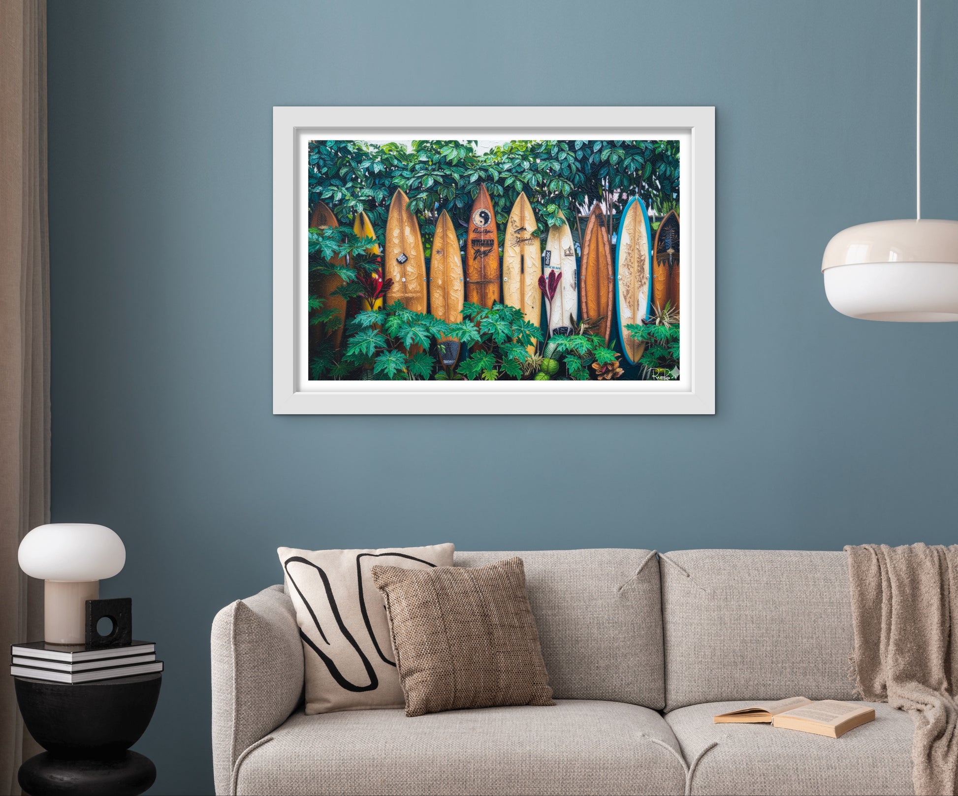 Framed artwork of surfboards in a forest displayed above a sofa in a living room.
