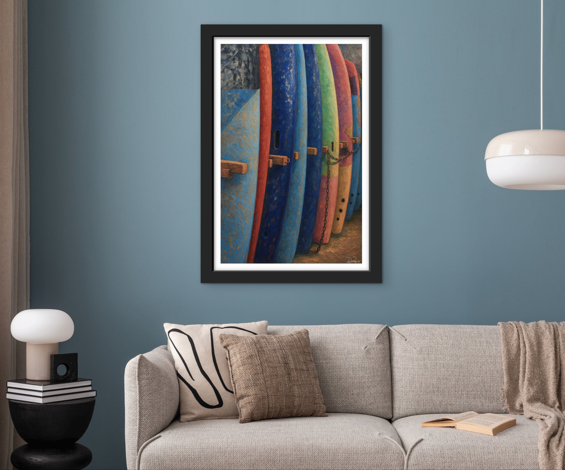 Framed artwork of colorful surfboards on a blue wall above a beige sofa.