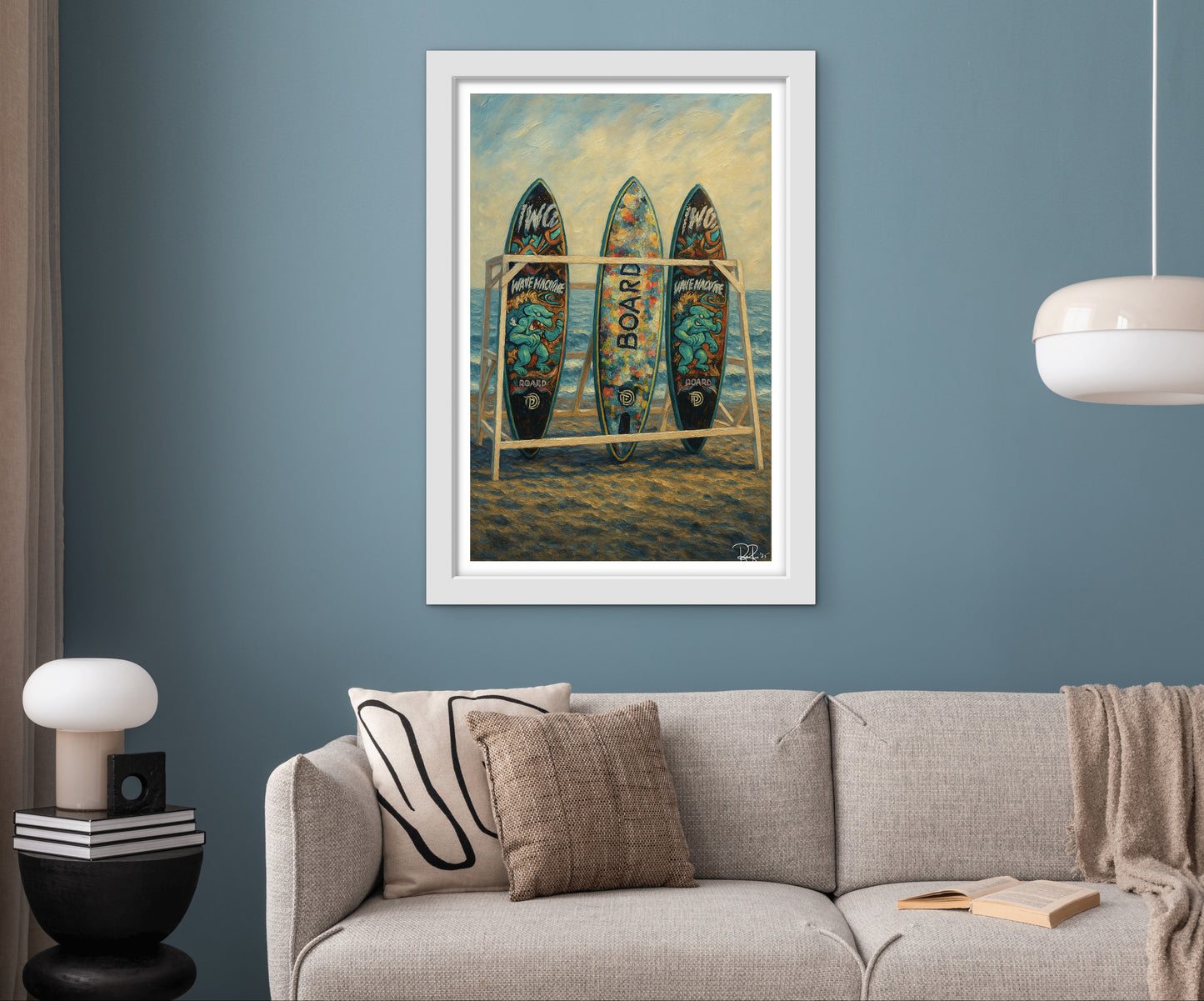 Framed artwork of surfboards on a beach wall above a sofa.