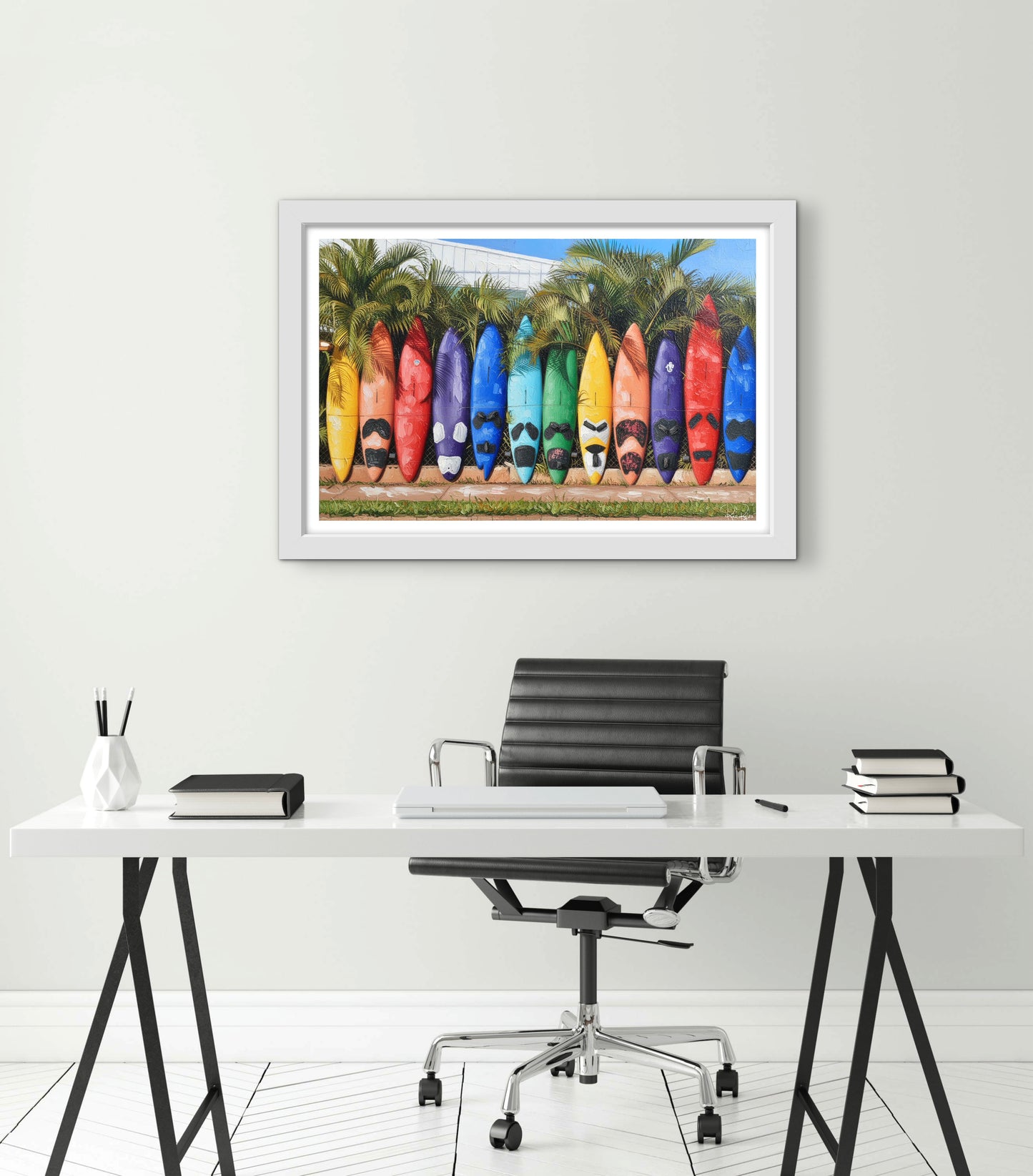 Framed artwork of colorful surfboards on a wall above a desk.