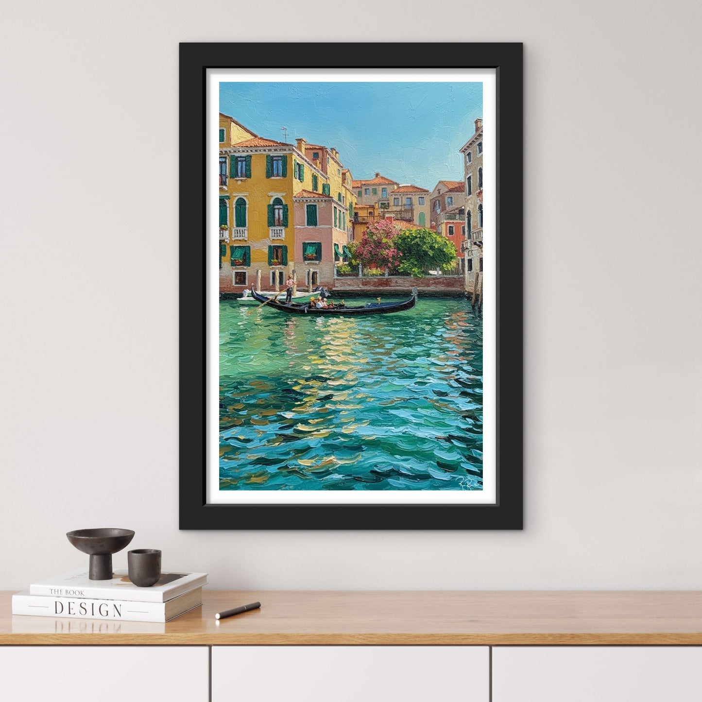 Framed painting of a canal scene with buildings and a gondola on a white wall.