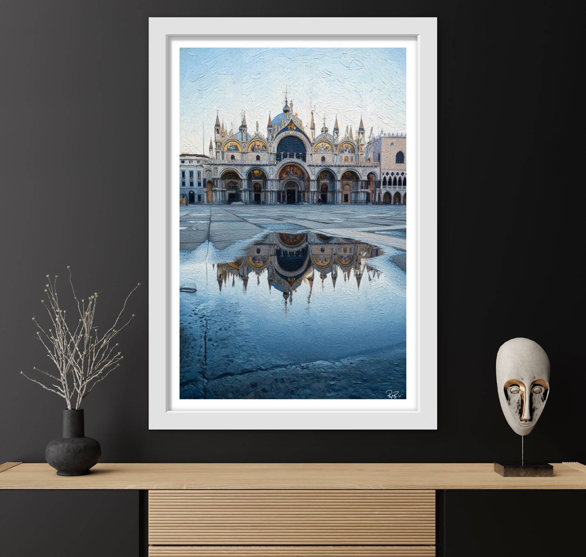 Framed artwork of a cityscape with a large building reflection in water on a dark wall.