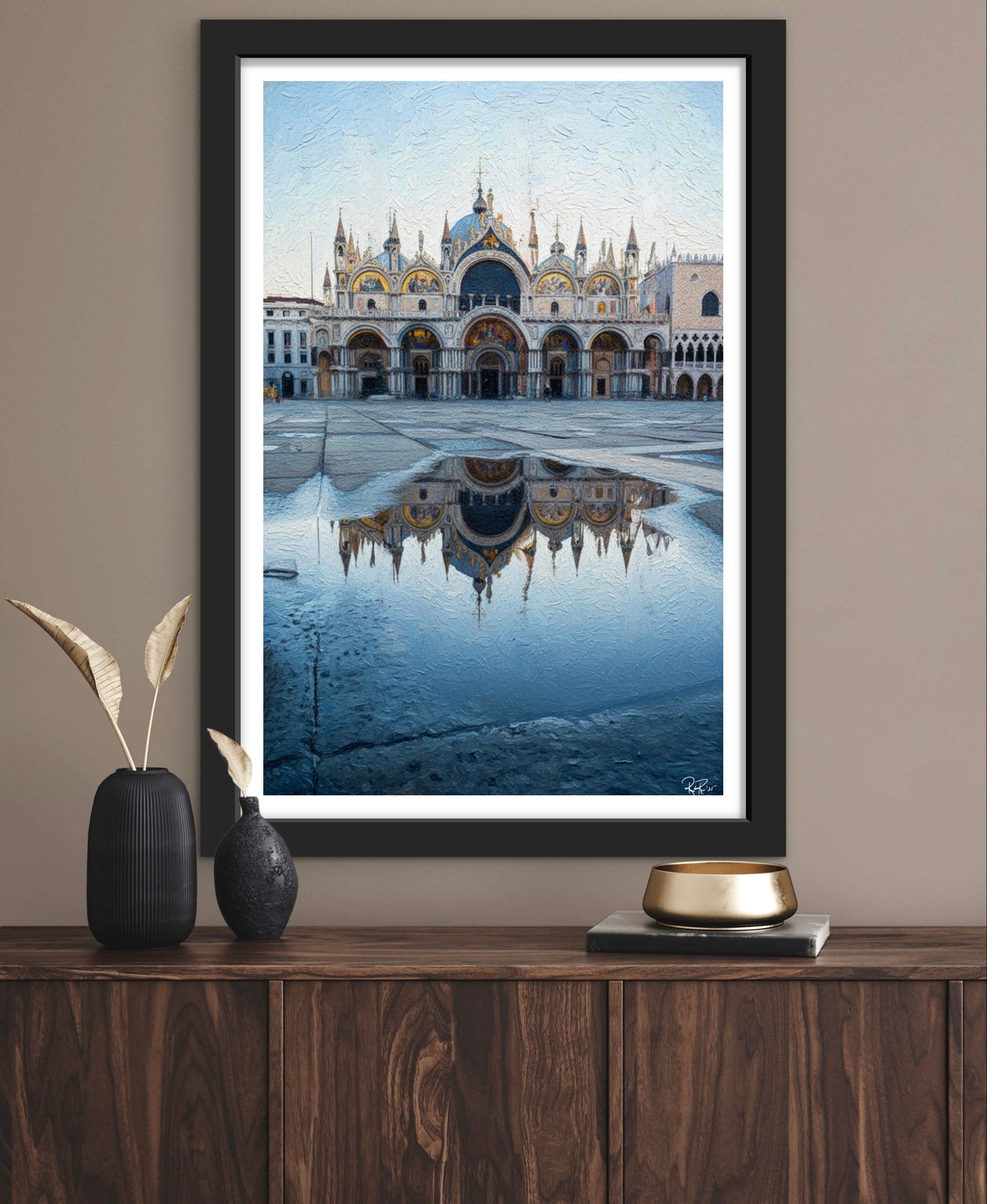 Framed artwork of a architectural scene with reflection on a wall above a wooden shelf.