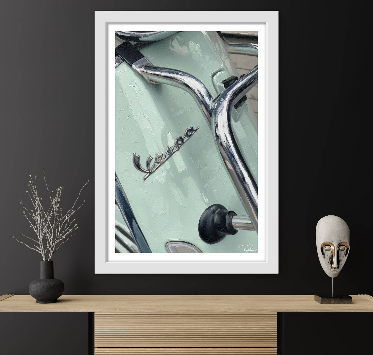 Framed Vespa poster on a dark wall with decorative items below.