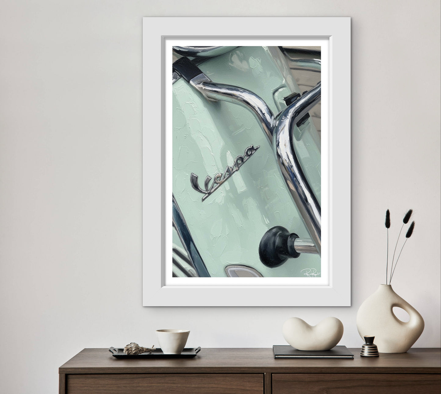 Framed artwork of a Vespa scooter on a wall above a wooden console table with decorative items.