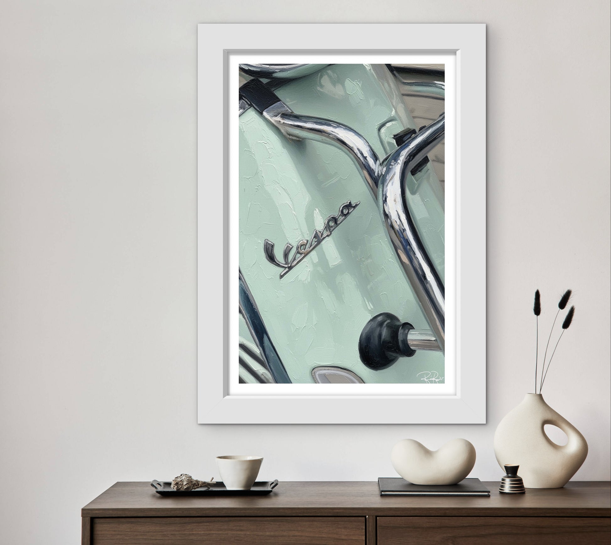 Framed artwork of a Vespa scooter on a wall above a wooden console table with decorative items.