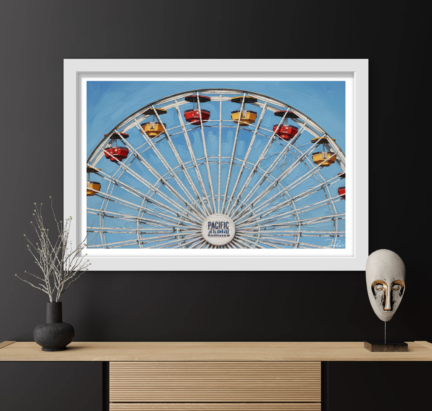 Framed photograph of a Ferris wheel against a blue sky, displayed on a dark wall with decorative items.