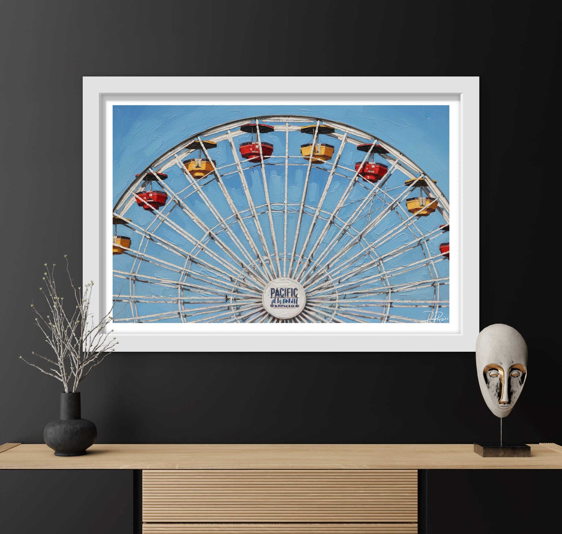 Framed photograph of a Ferris wheel against a blue sky, displayed on a dark wall with decorative items.